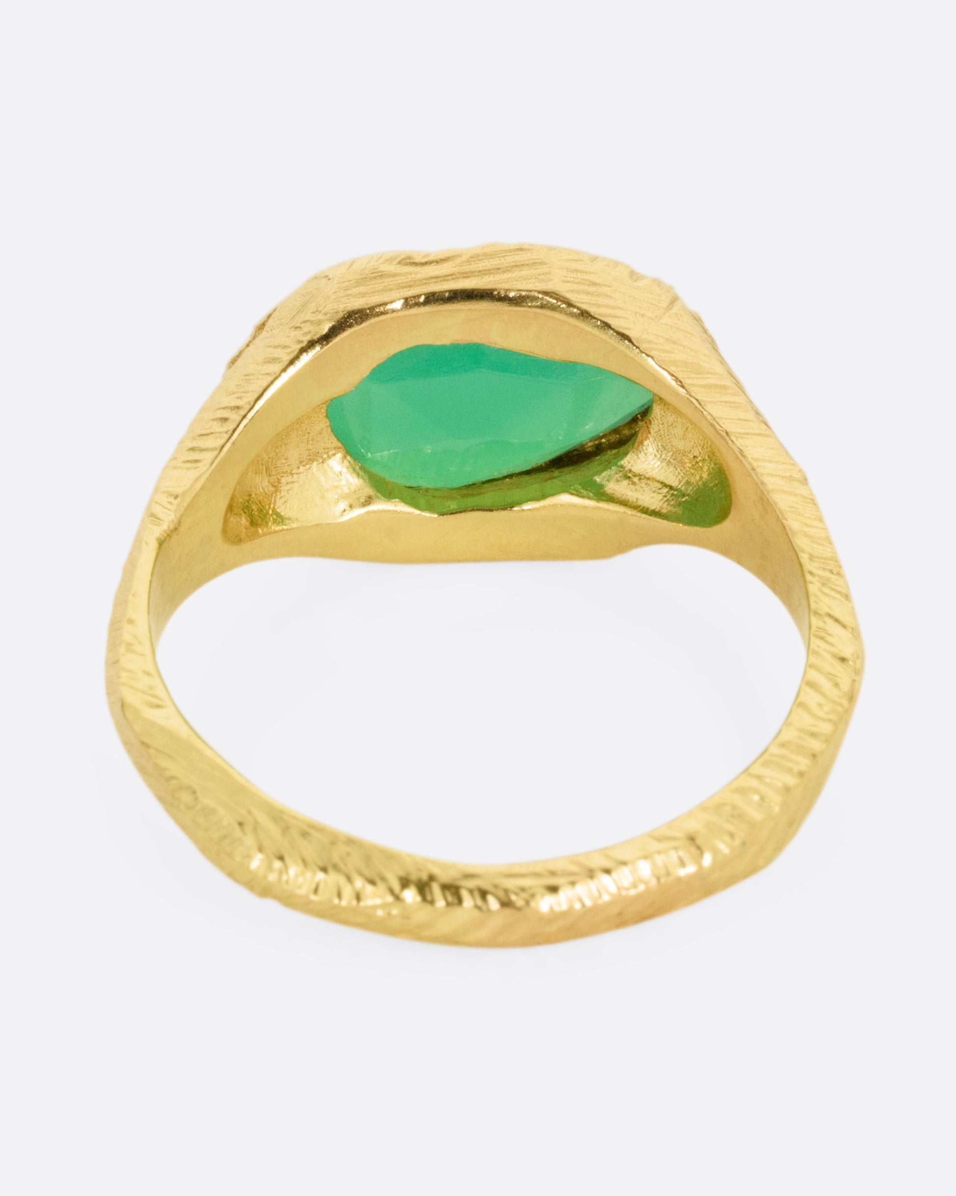 A yellow gold ring with a large chrysoprase, shown from the back.