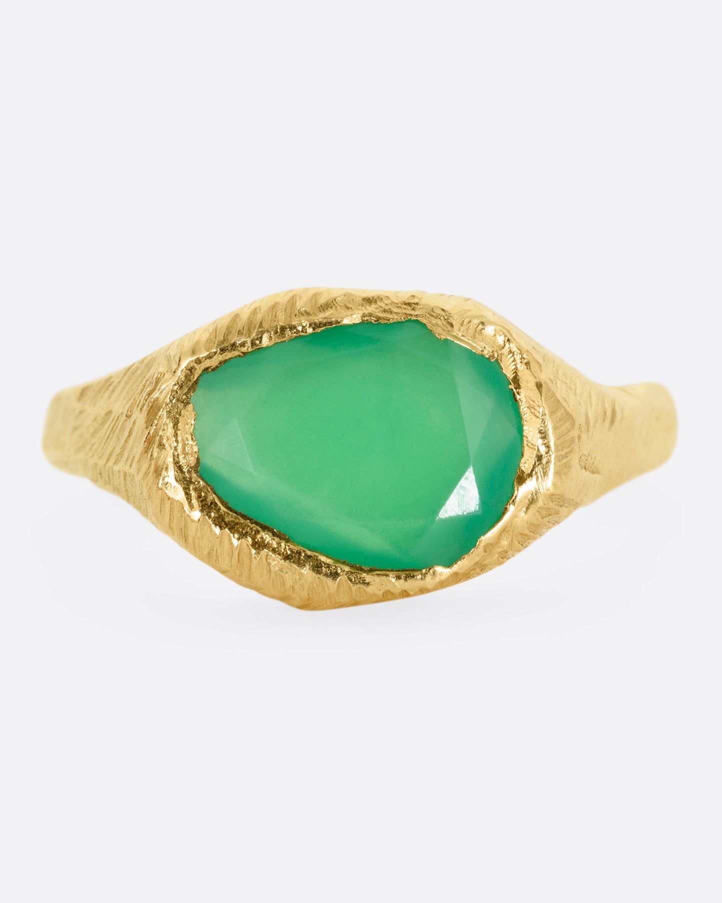 A yellow gold ring with a large chrysoprase, shown from the front.