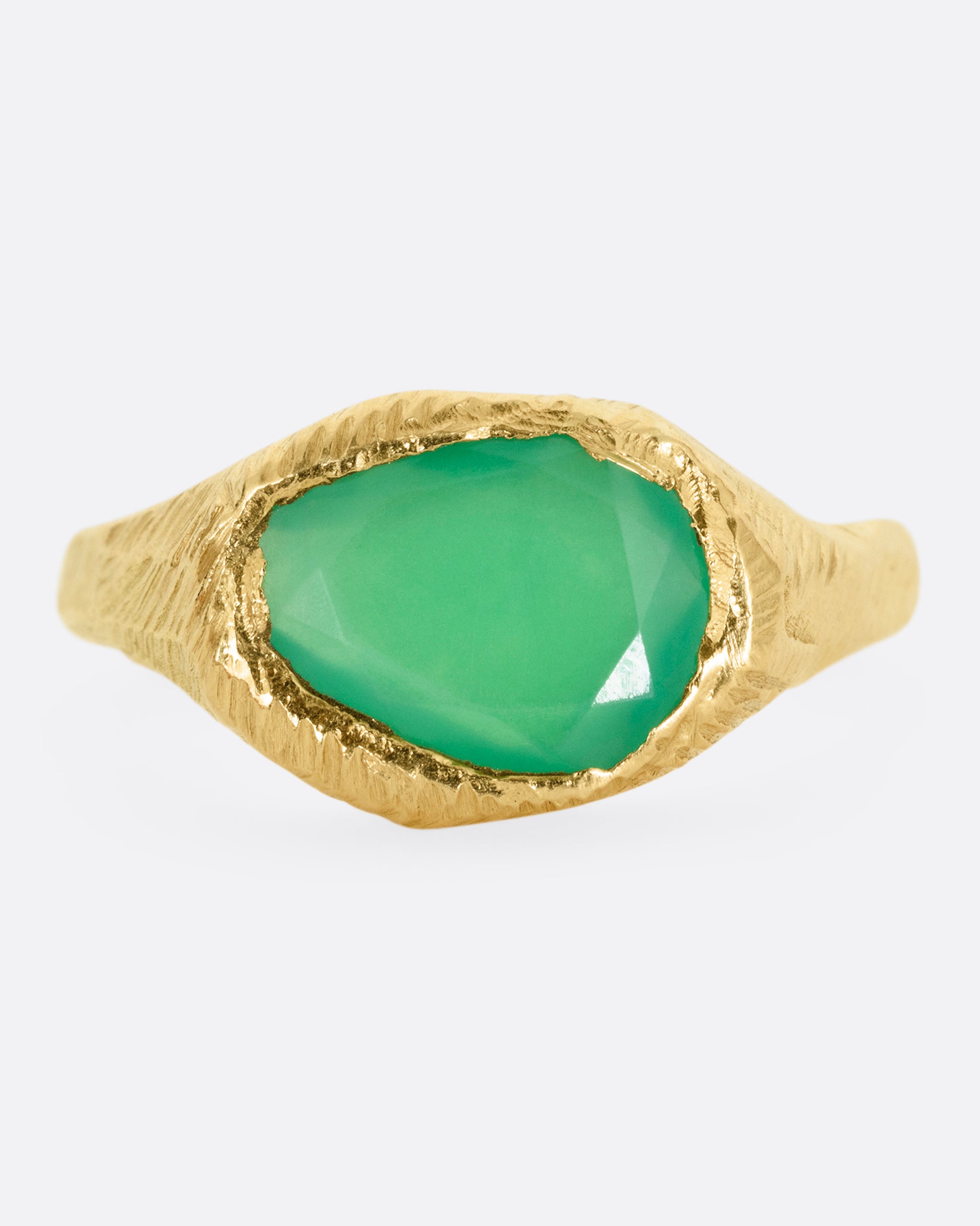 A yellow gold ring with a large chrysoprase, shown from the front.
