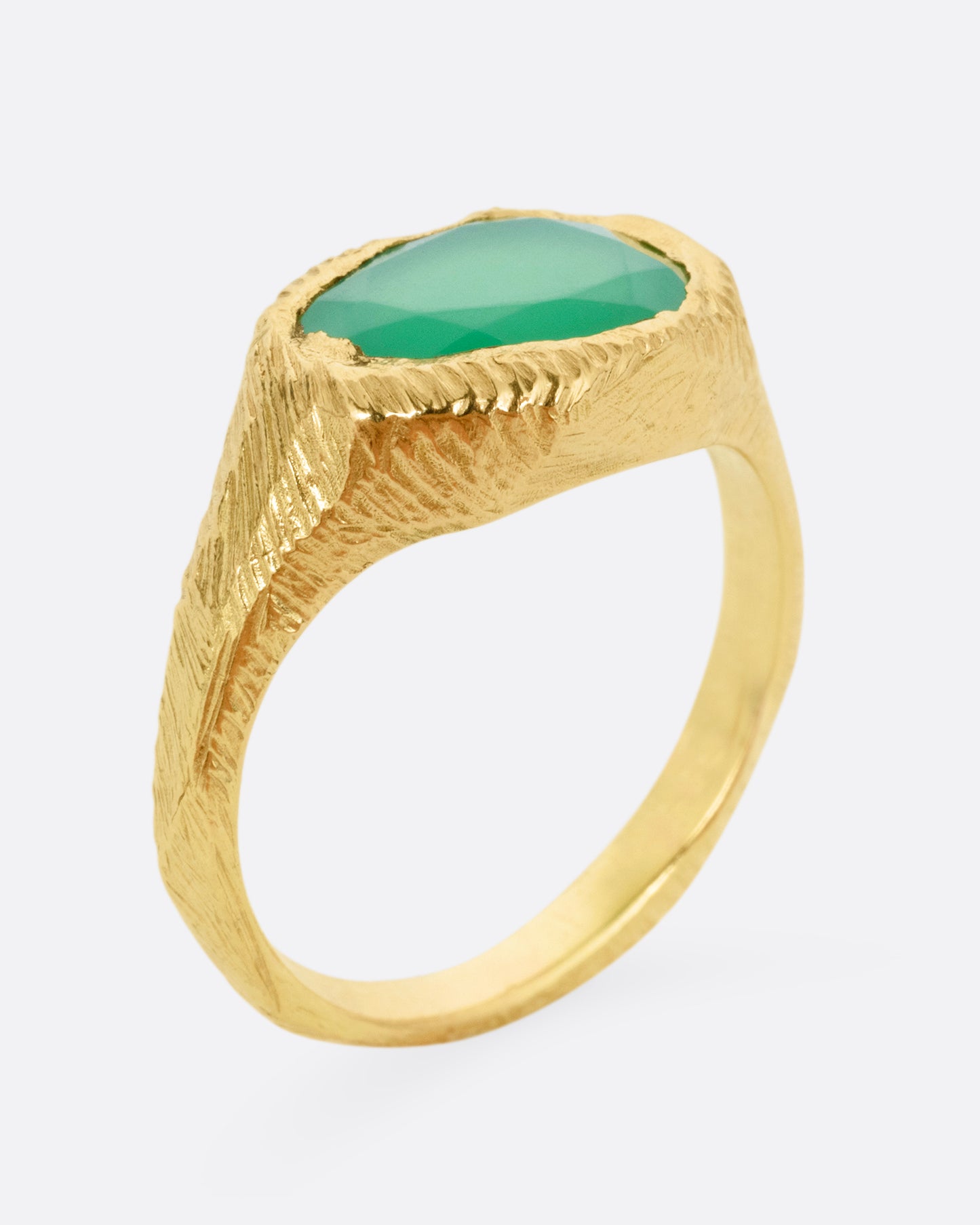 A yellow gold ring with a large chrysoprase, shown from the side standing up.