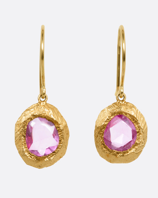 A pair of yellow gold drop earring with rose cut pink sapphires. Shown from the front.
