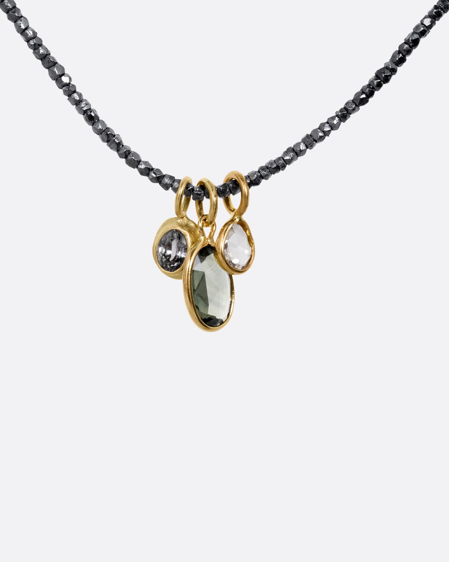 A necklace with silver beads and sapphire and diamond charms, shown from the front.