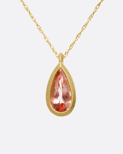 A yellow gold necklace with a bezel set teardrop shaped Imperial Topaz,shown from the front.