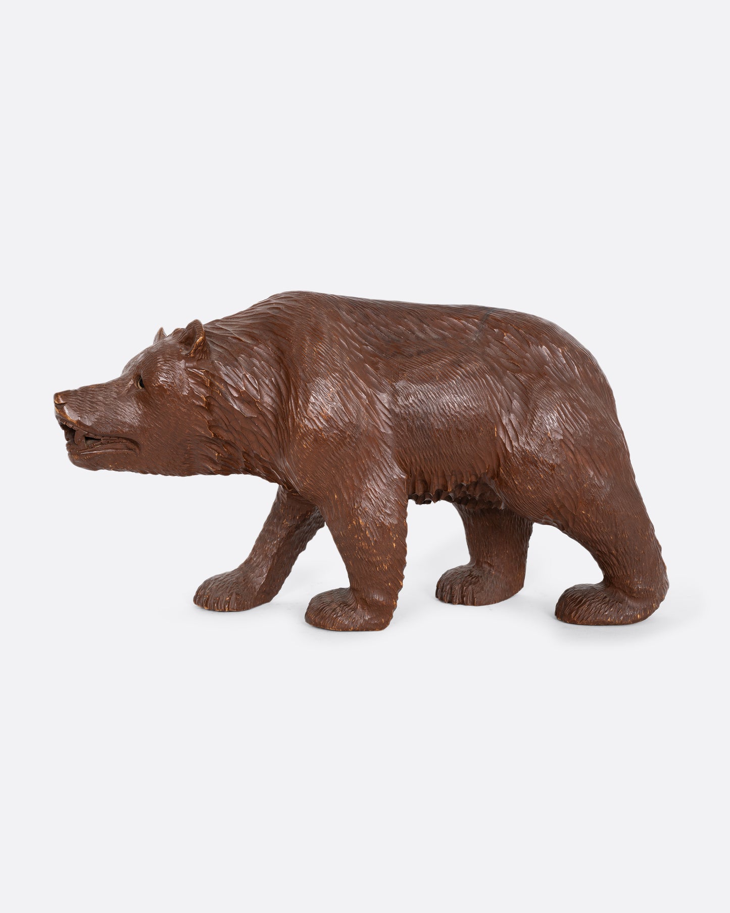 A wooden bear with glass eyes. Shown from the side.