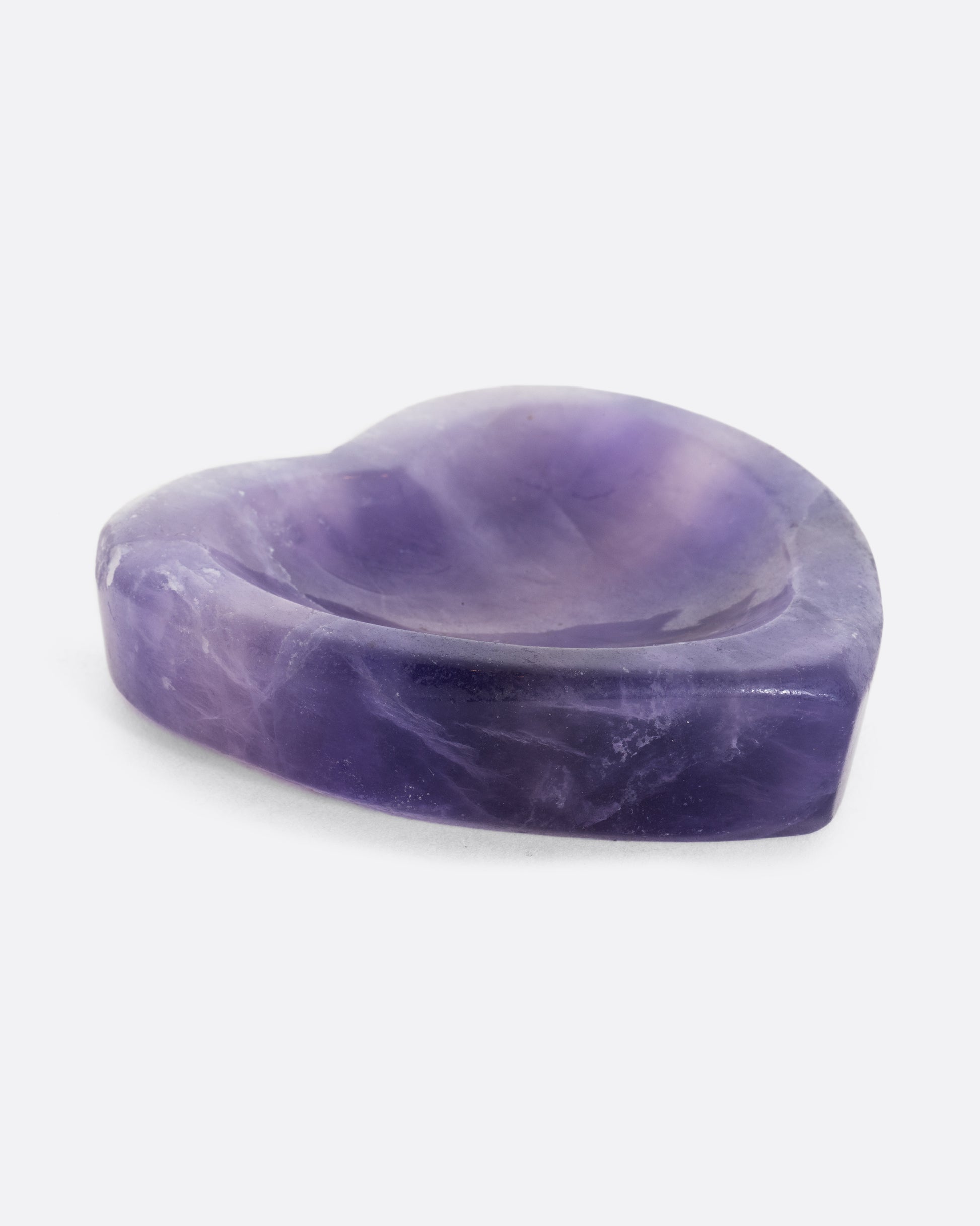 A purple fluorite stone heart shaped bowl. Shown laying flat.