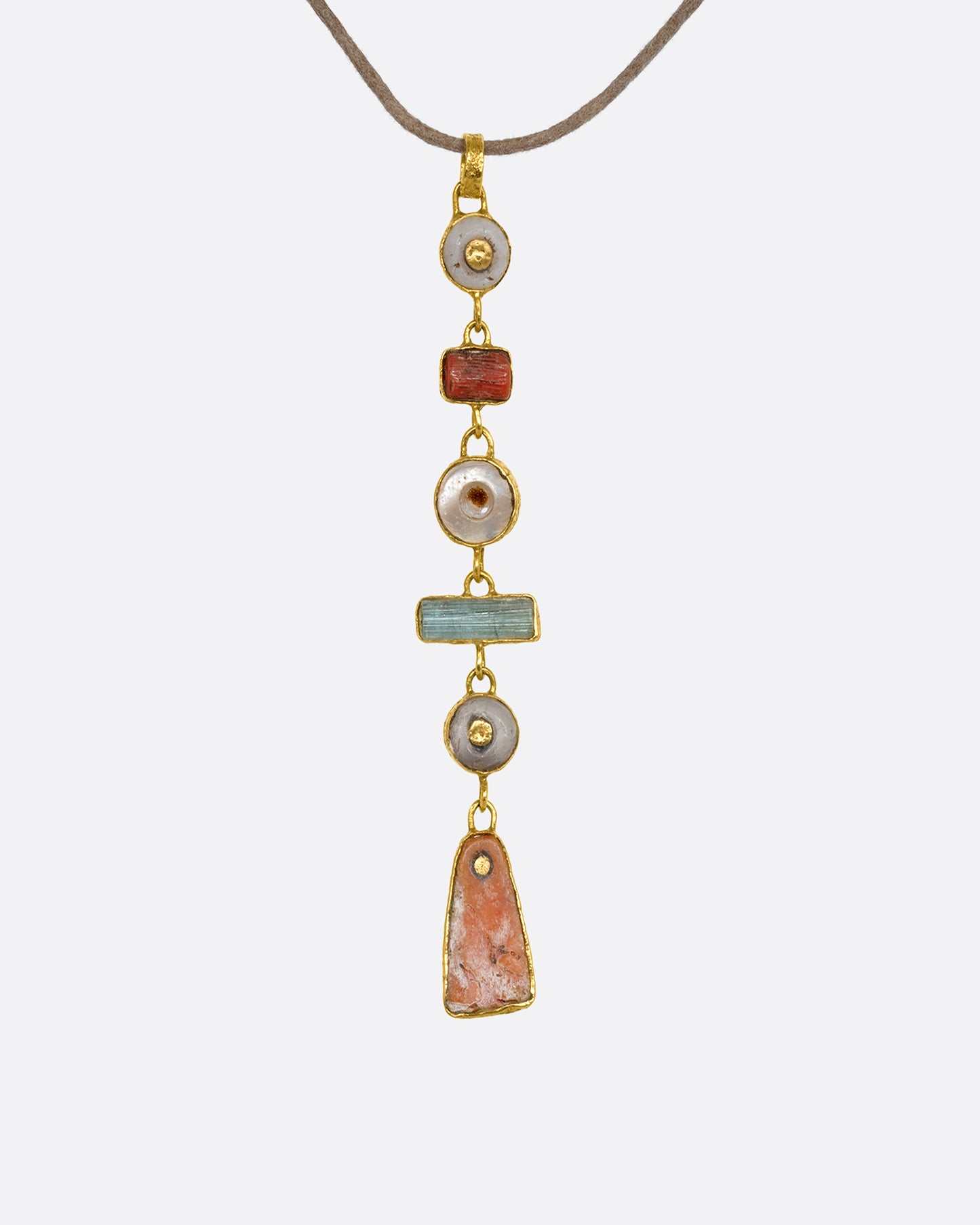 A tan cord necklace with six pre columbian elements hanging from it in a column, each wrapped in 22k gold. View from the back.