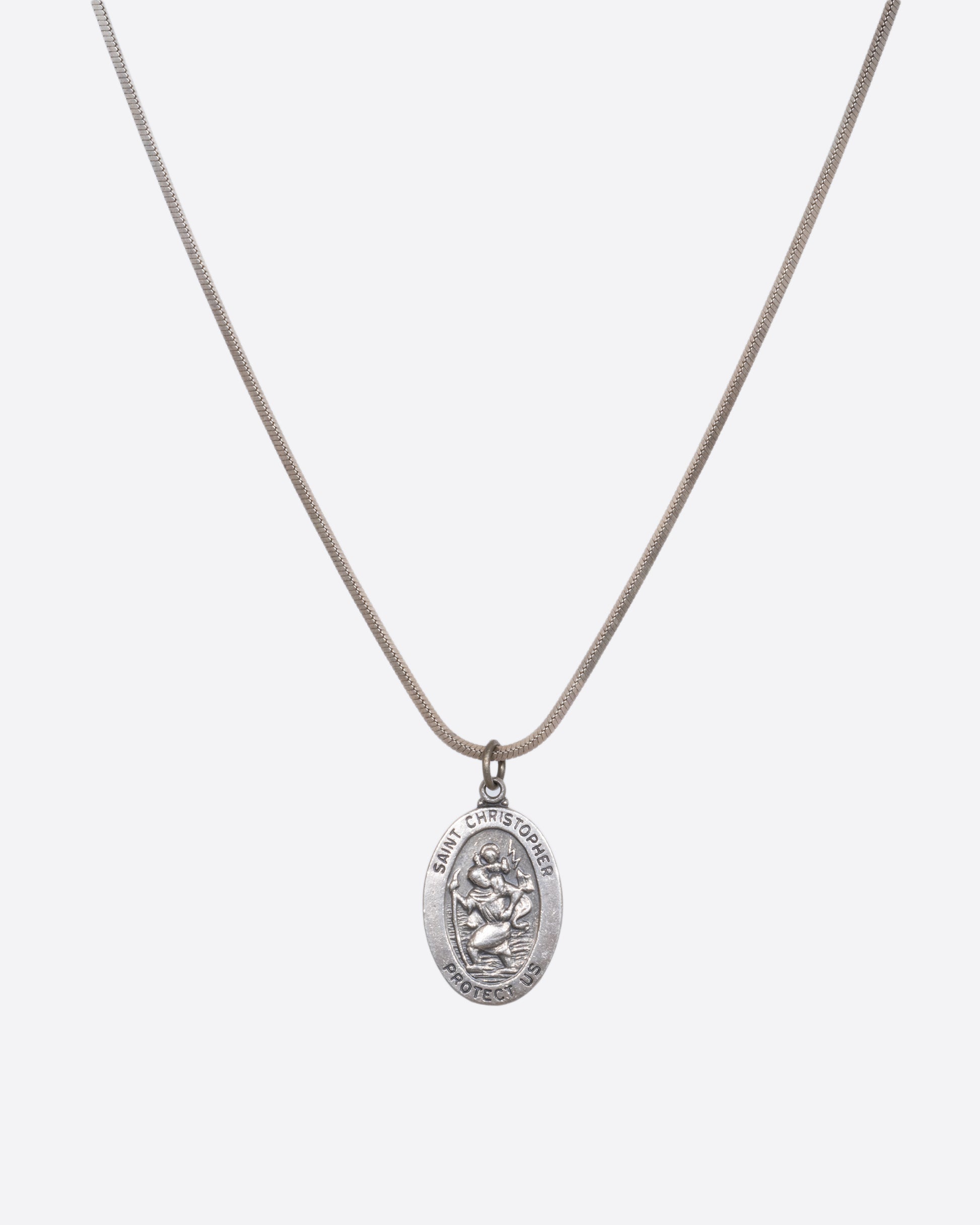 A sterling silver St. Christopher pendant hanging from a snake chain. View hanging on a chain.