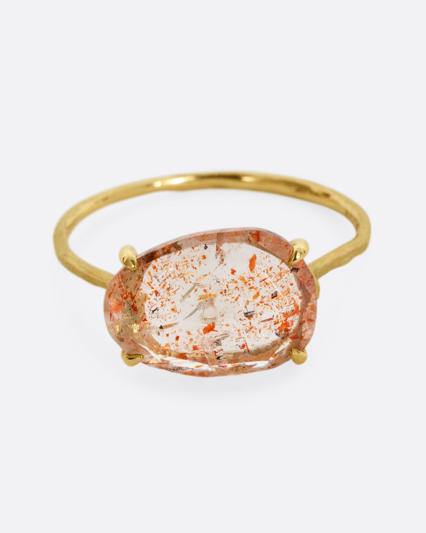A yellow gold ring with a prong set sunstone. Shown from the front.