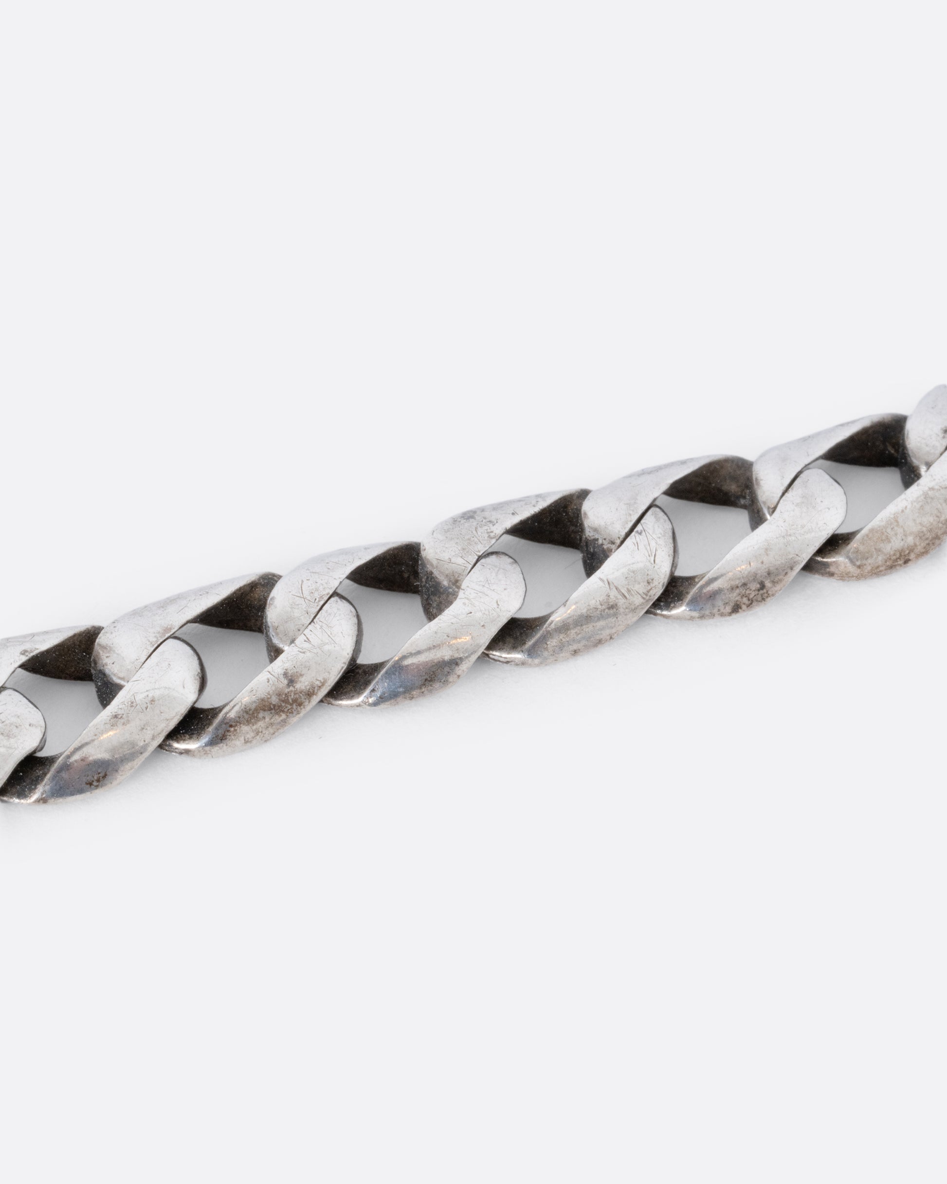 Sterling silver flat curb chain bracelet. Shown close up.