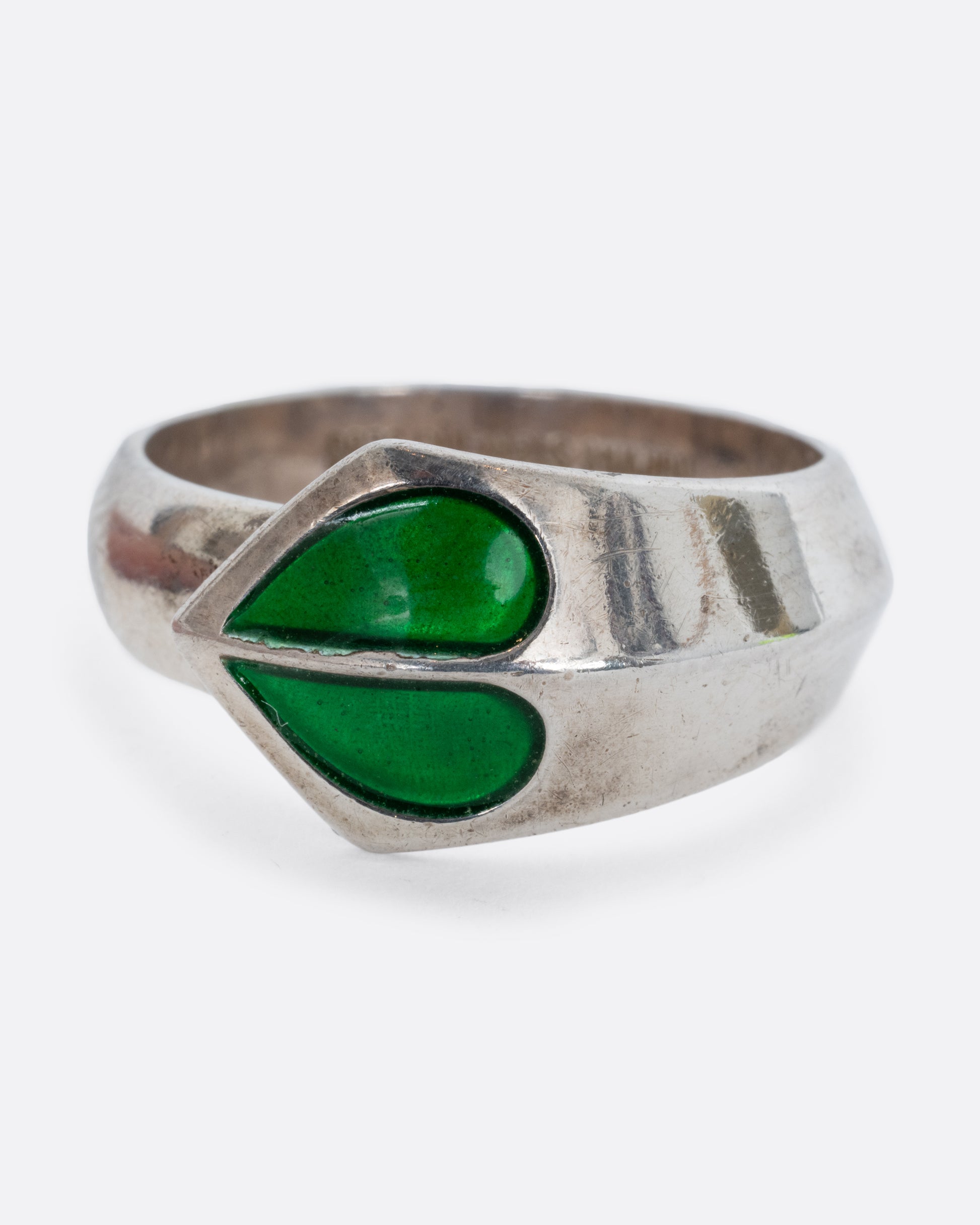 A sterling silver ring with a split green enamel heart. Shown from the front.