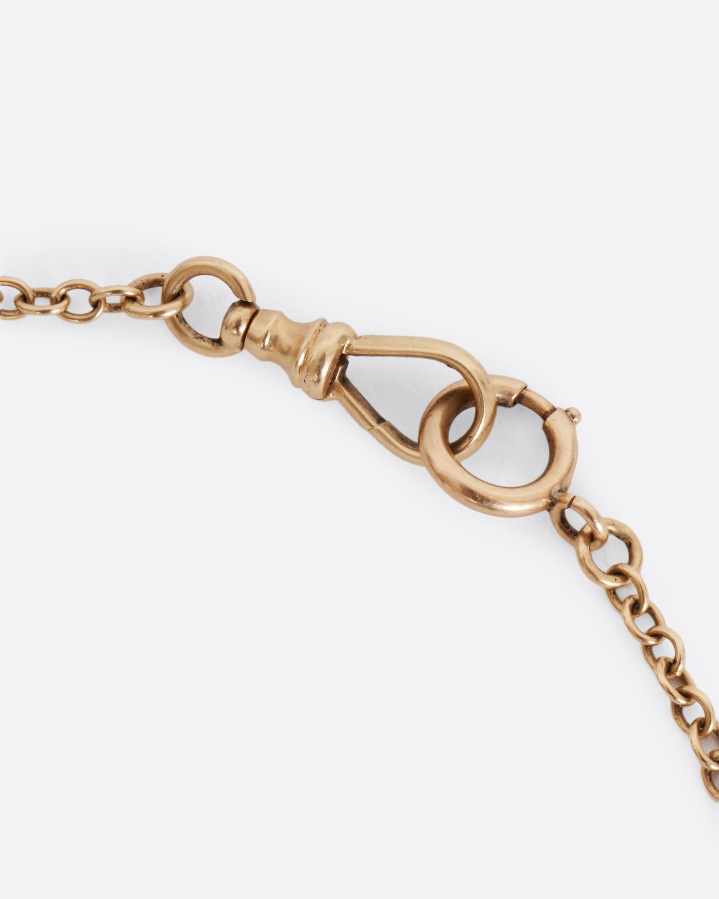 A yellow gold watch chain with textured elongated bar links. View of the clasp.