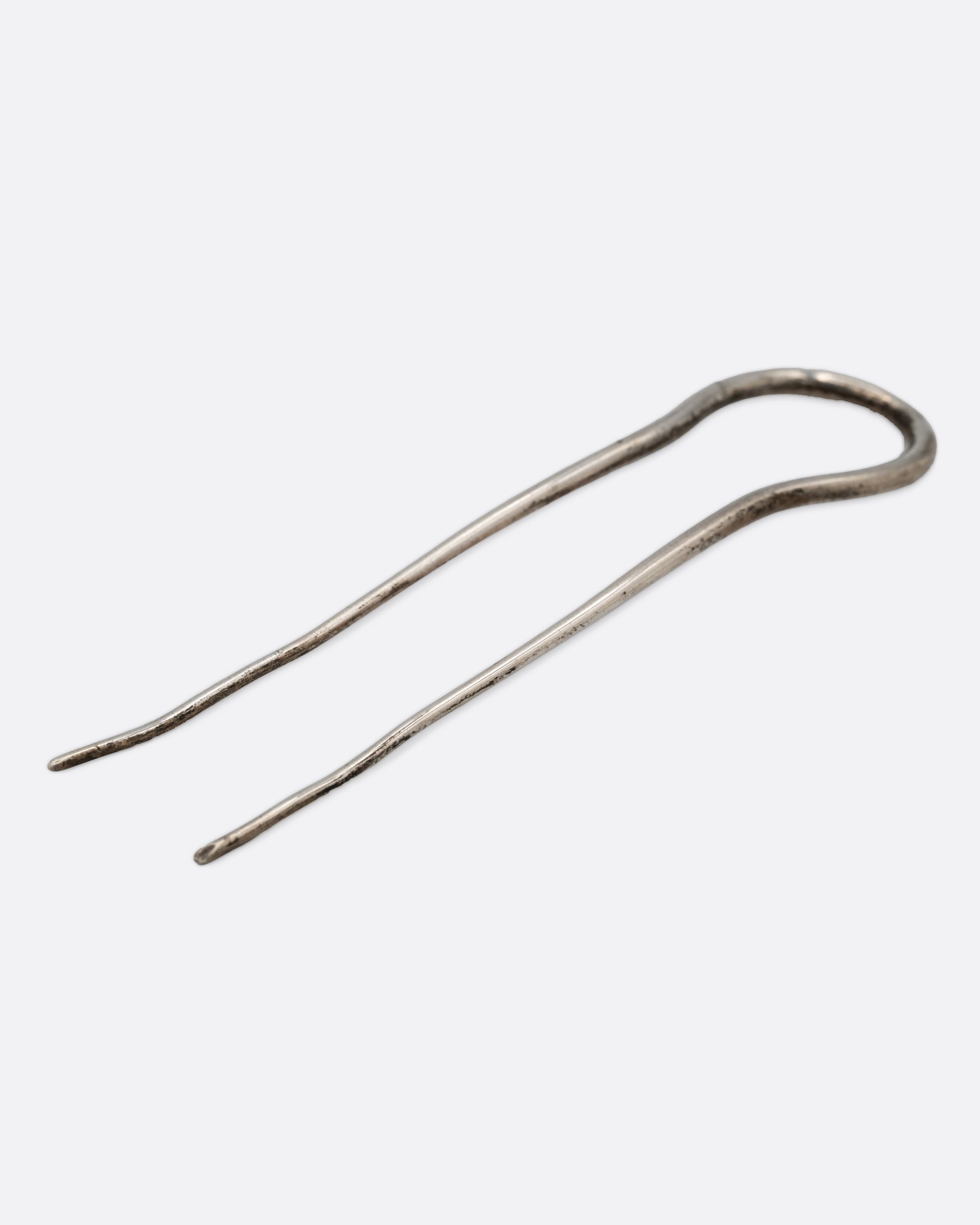 A silver hair pin with an arch at the top, shown lying flat.