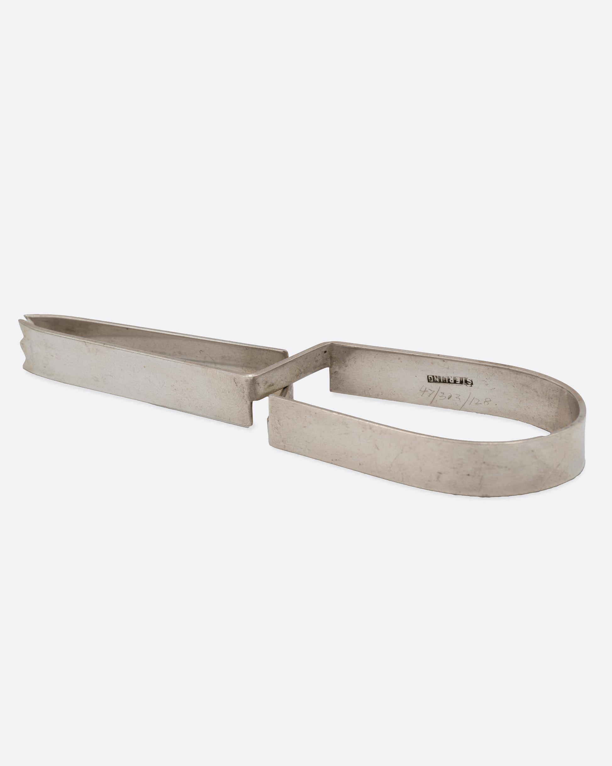 Stainless steel ice tongs with an arched handle, shown on their side.