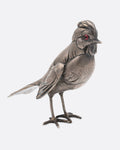 A silver bird figurine, shown from the side.