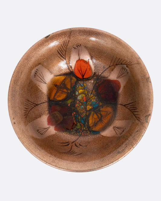 An enamel bow with an abstract botanical pattern, shown from the top.