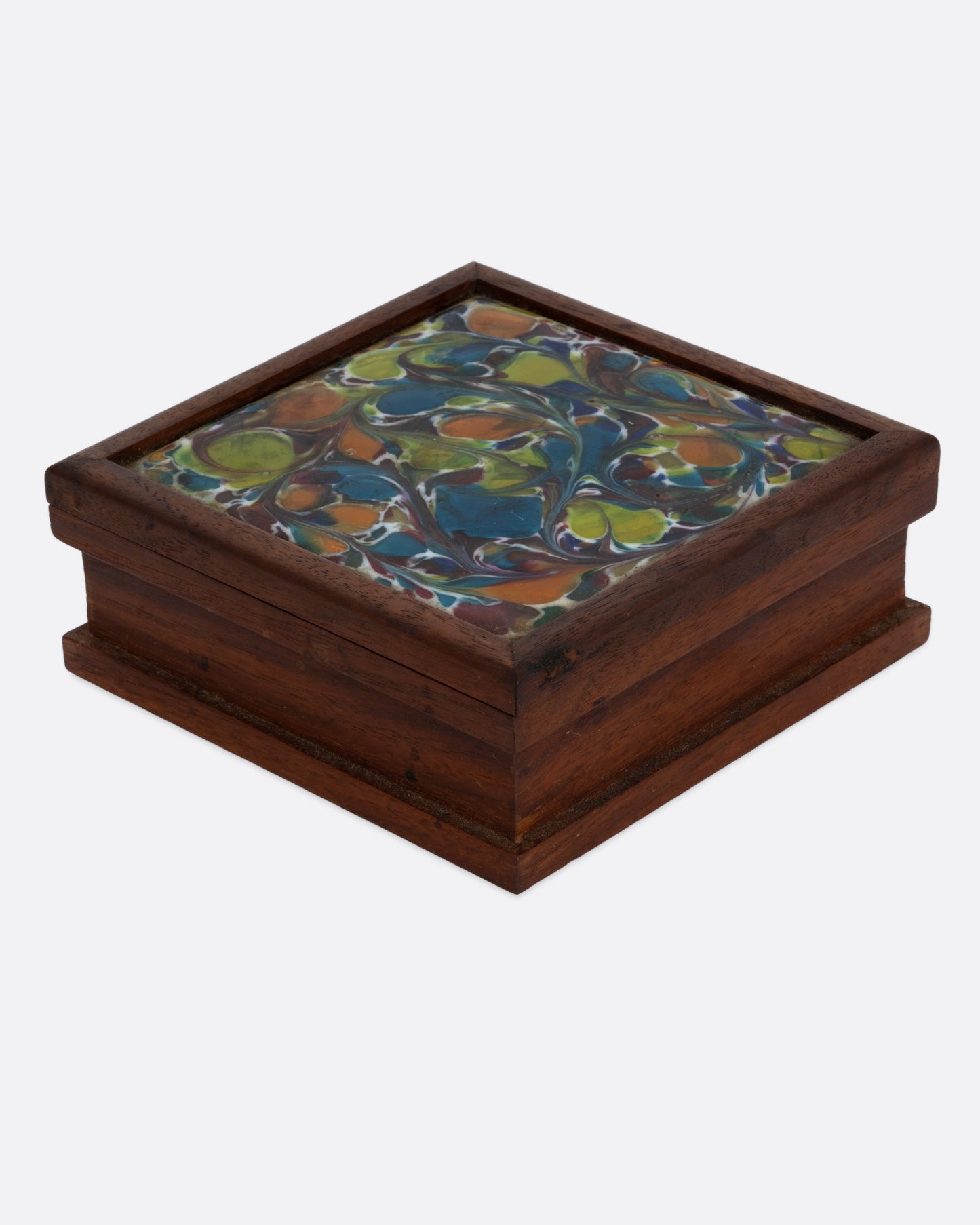 A wooden cigarette box with an abstract enamel design. Shown from the side.