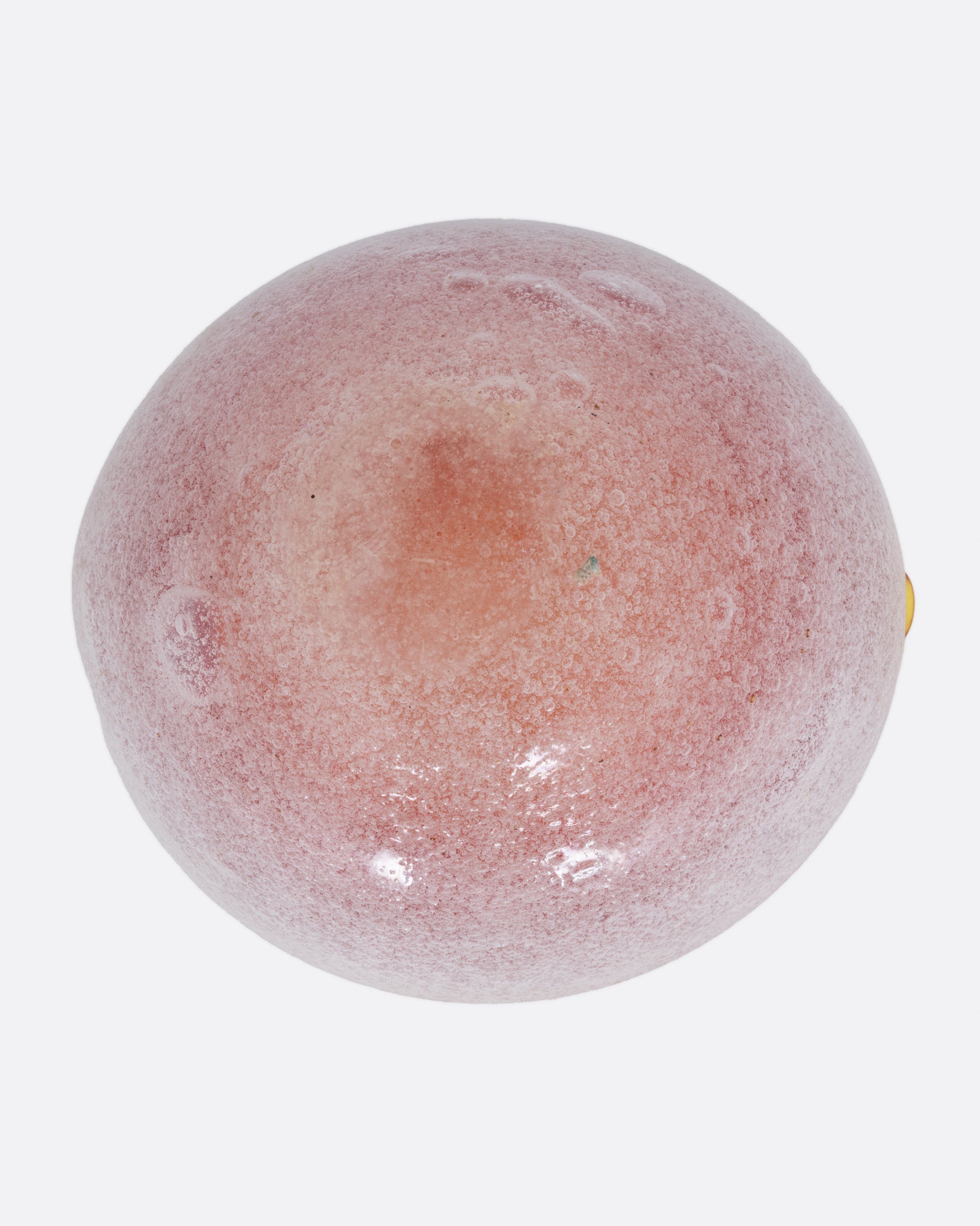 An orange and white blown glass ashtray, shown from the bottom.