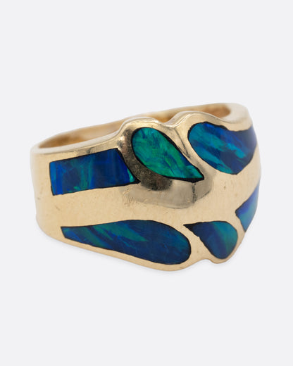 A yellow gold ring with an abstract inlay of opal. Shown from the side.