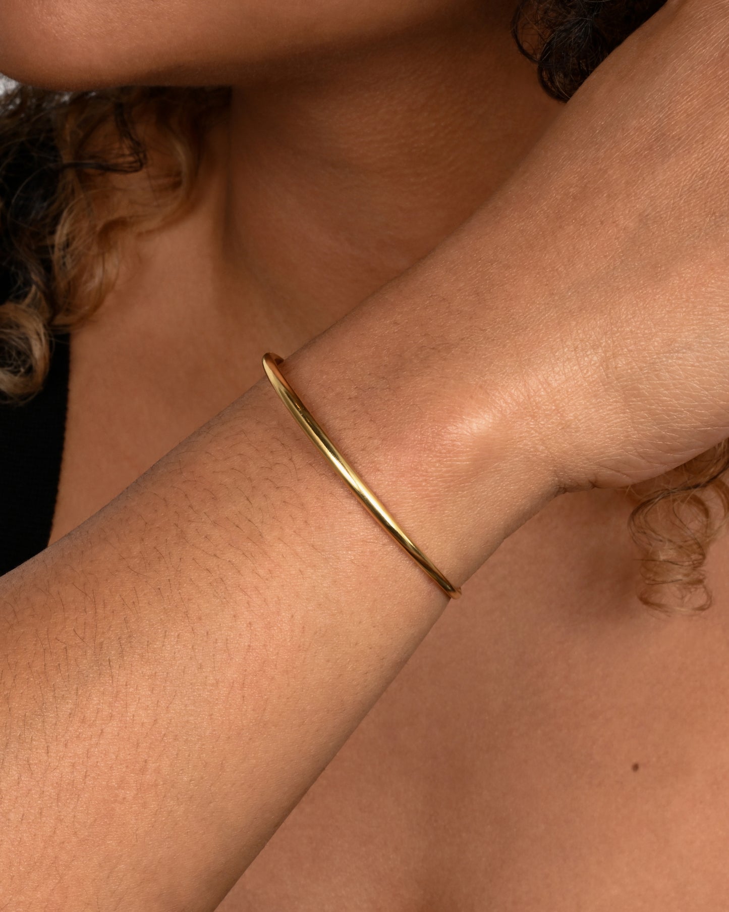 A yellow gold cuff bracelet. Shown worn.