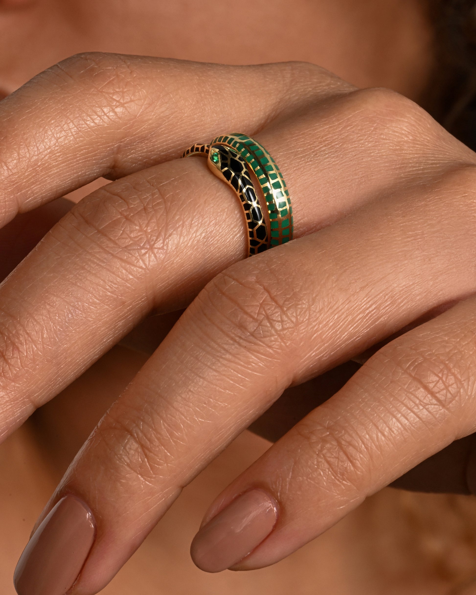 A yellow gold band with an irregular checkered pattern all the way around. Shown worn, styled with another band.