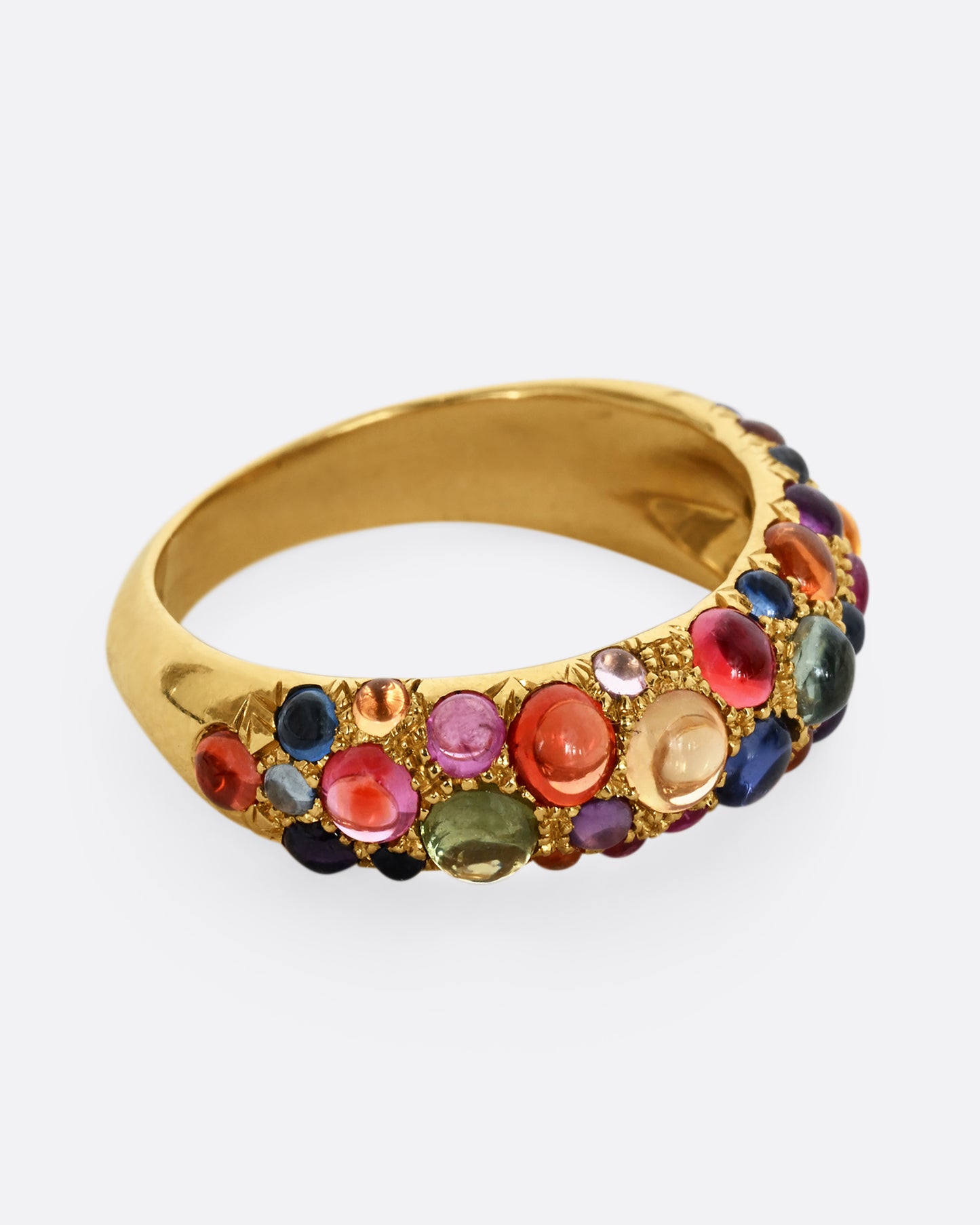 Multicolor sapphire cabochons set in an 18k yellow gold band. Shown from the side.