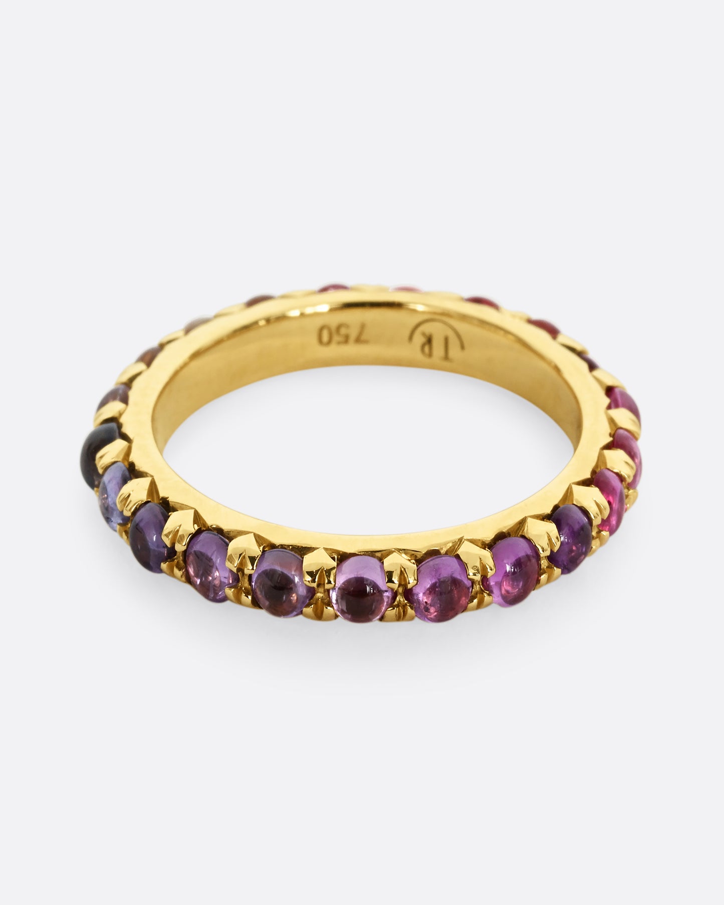 A yellow gold eternity band with pink and purple sapphire cabochons. 