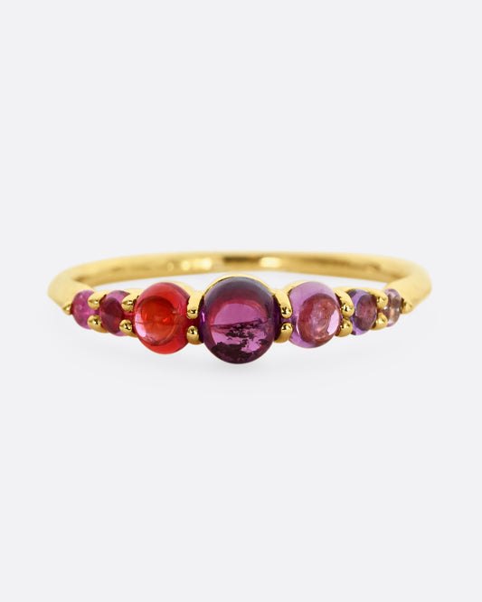 Pink and purple graduated sapphires set in 18k yellow gold. View from the front.