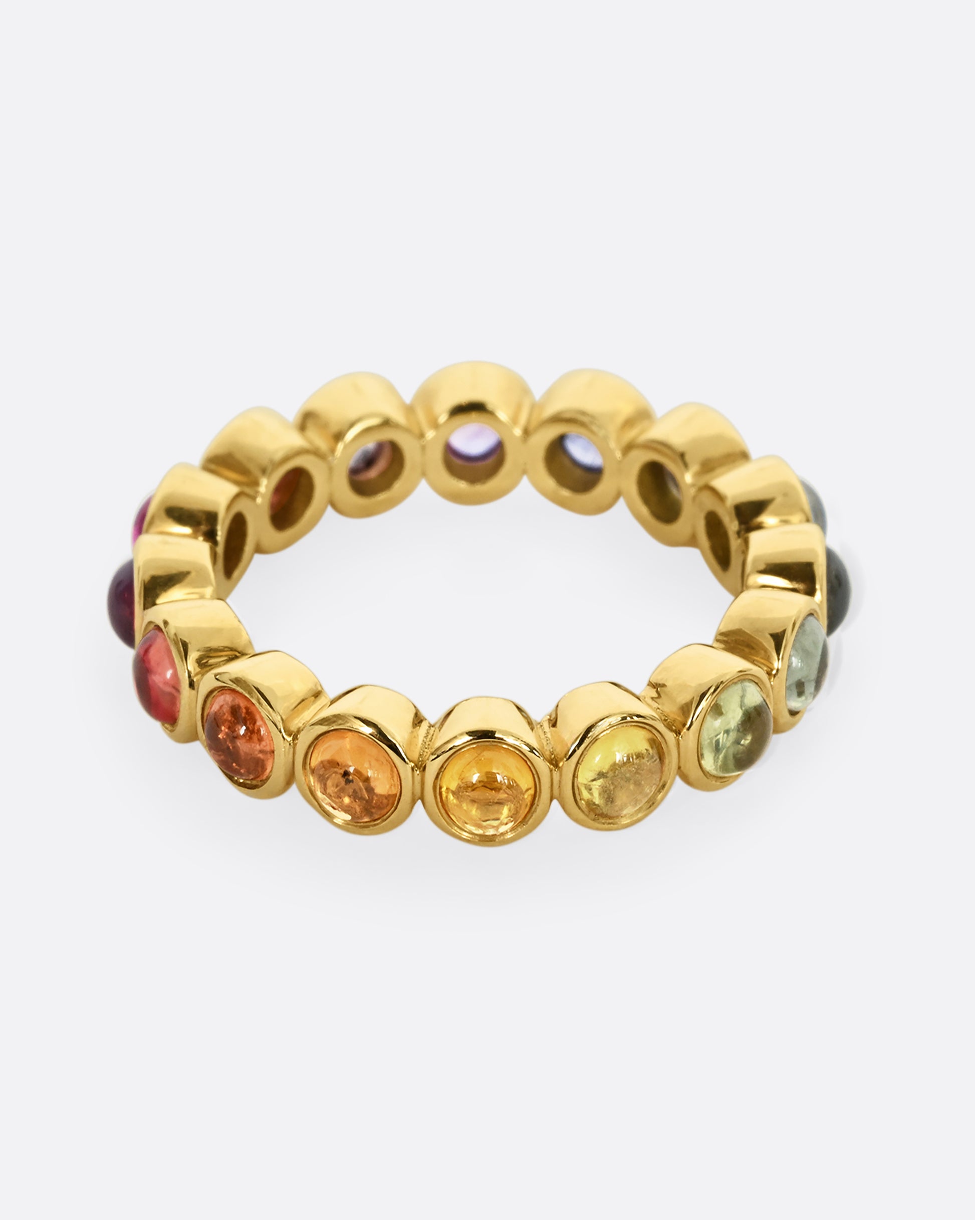 A yellow gold half eternity band with multicolor bezel set sapphire cabochons. 