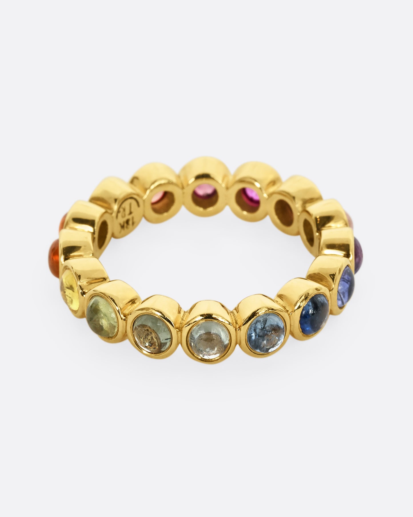 A yellow gold half eternity band with multicolor bezel set sapphire cabochons. 