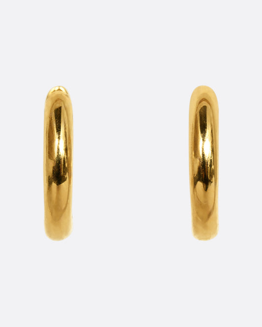 Yellow gold huggie hoops, shown from the front.