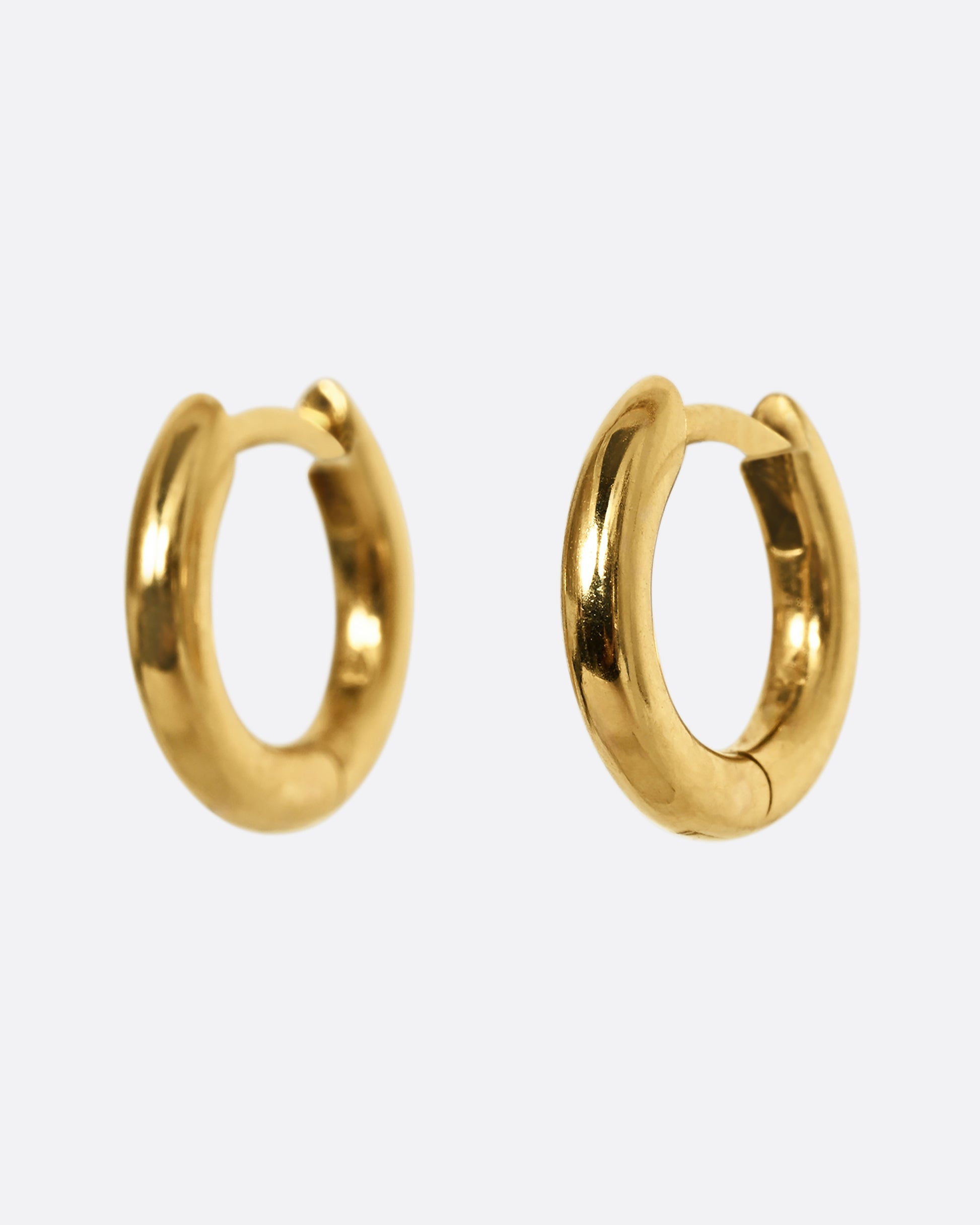 Yellow gold huggie hoops, shown from the side.