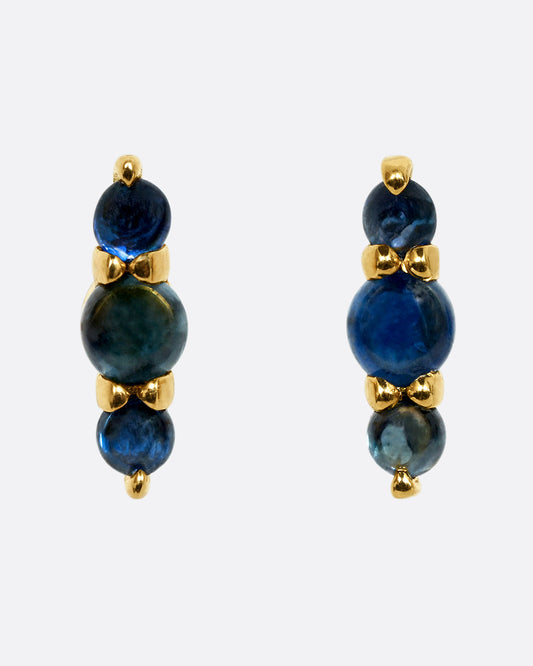 Stud earrings made of three blue sapphire cabochons set in yellow gold. Shown from the front.