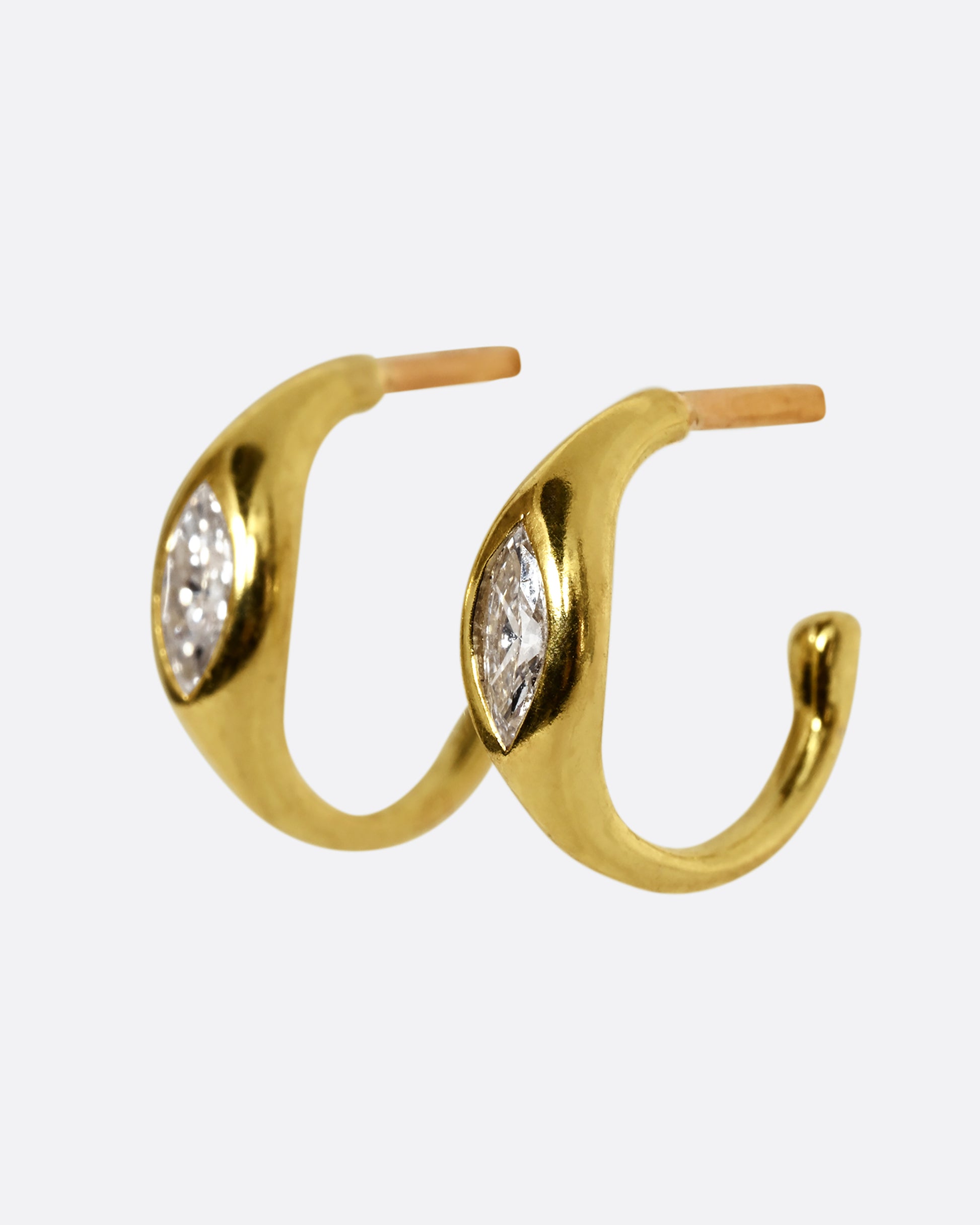 A yellow gold hoop earring with a marquis diamond, shown from the side, as a pair.