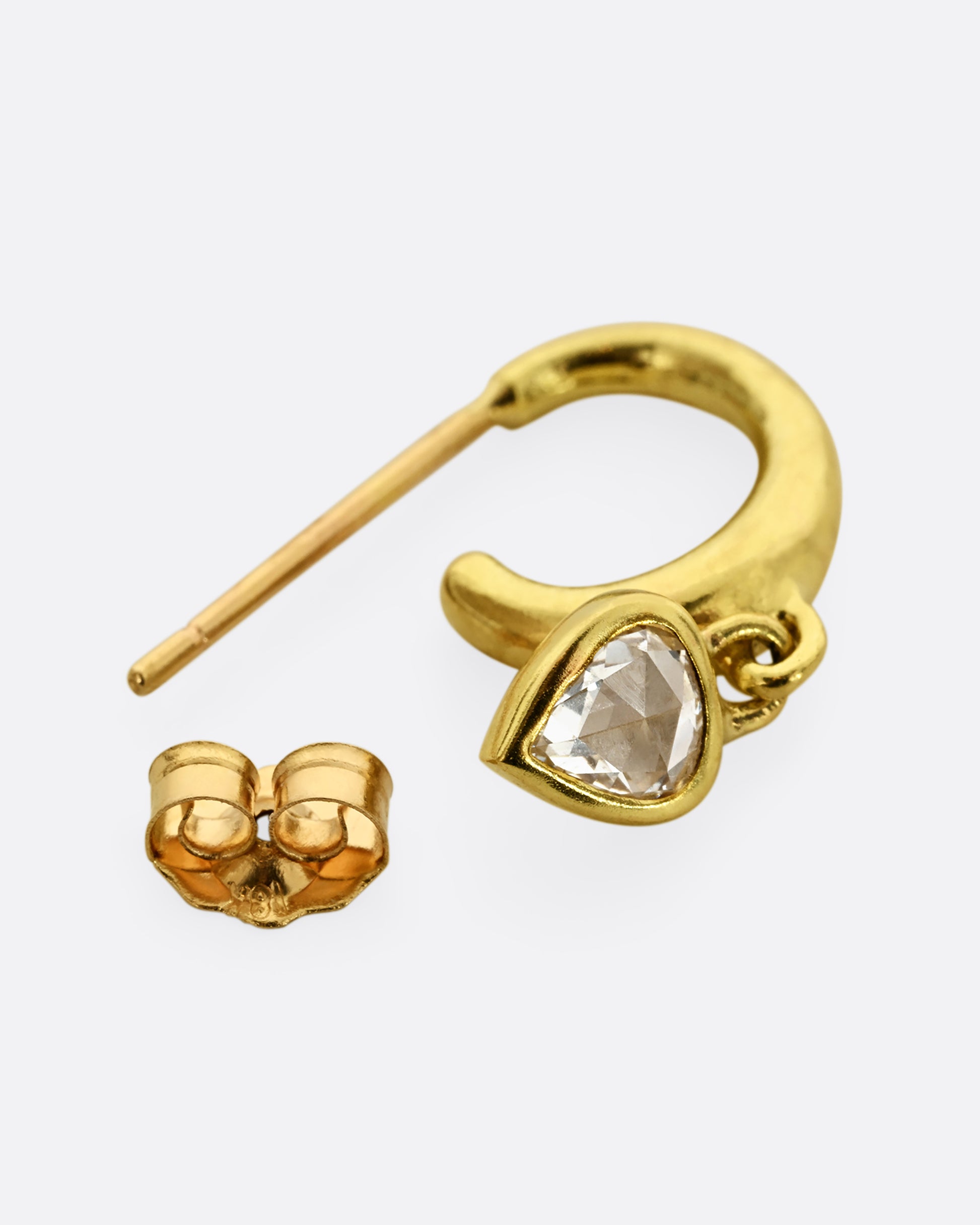 A yellow gold hoop earring with a diamond dangle, shown laying flat.