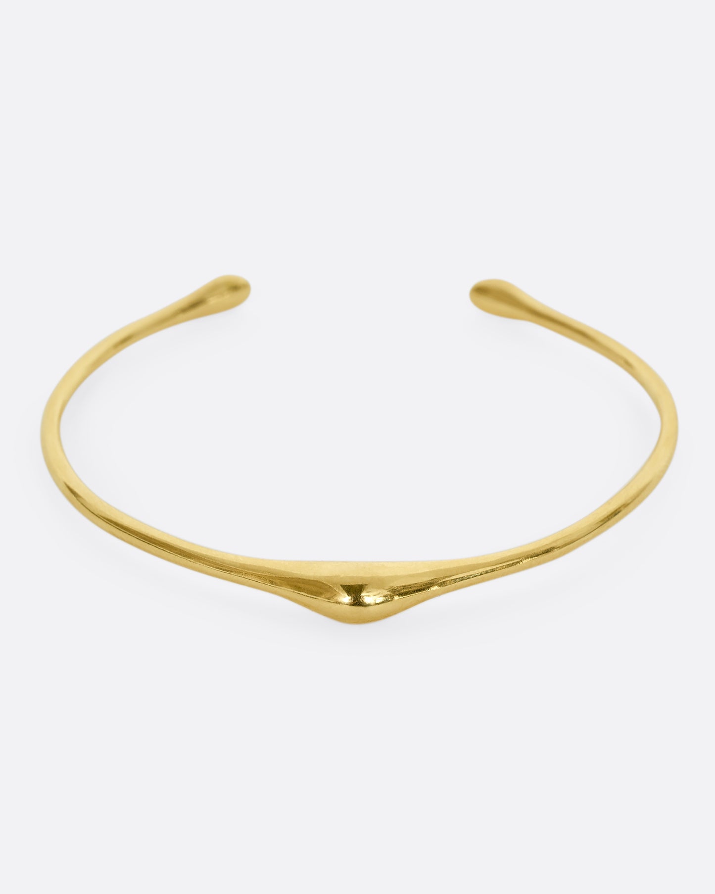 A yellow gold cuff bracelet with a bump. Shown from the front.