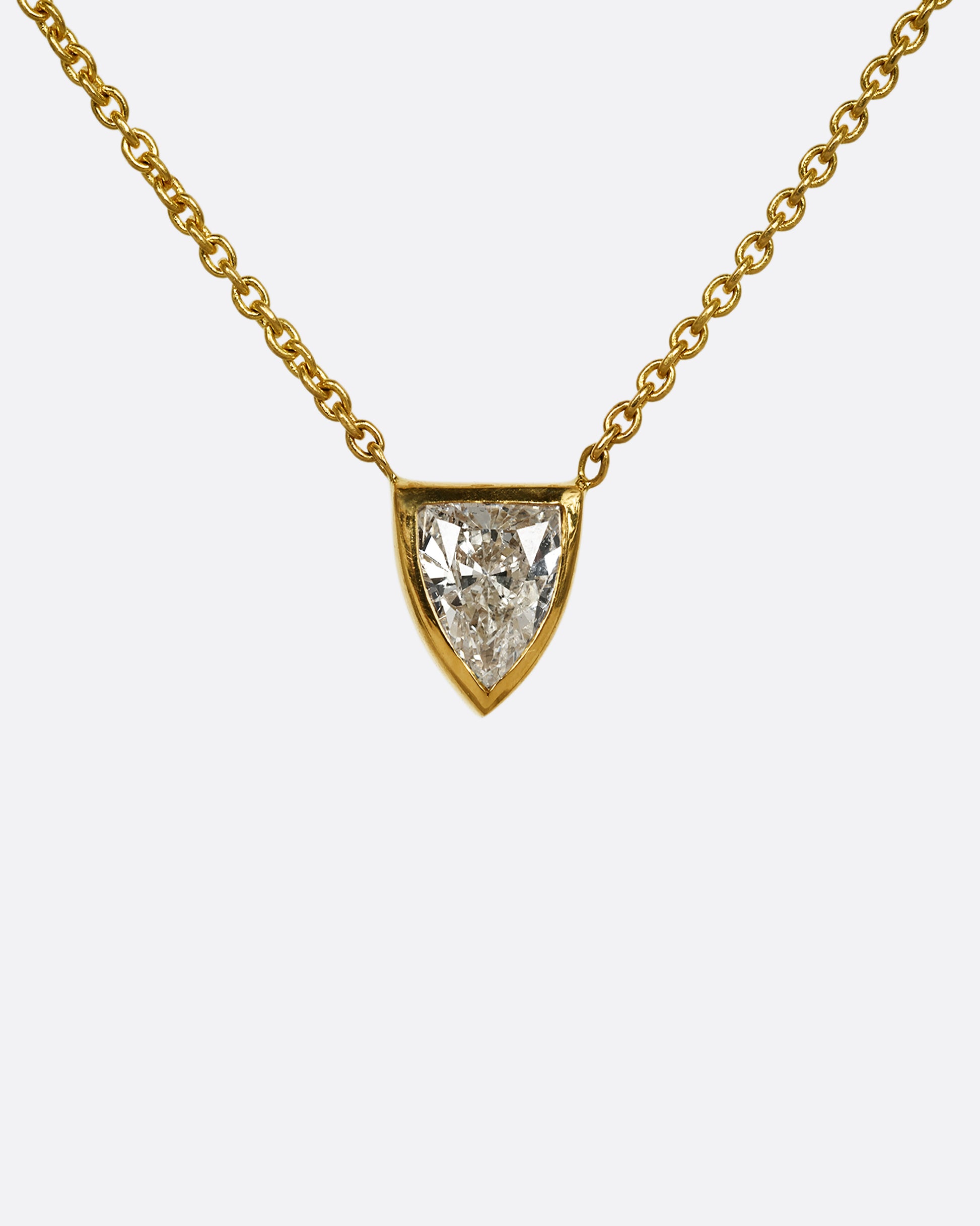 A yellow gold necklace with a shield shaped diamond. Shown from the front.