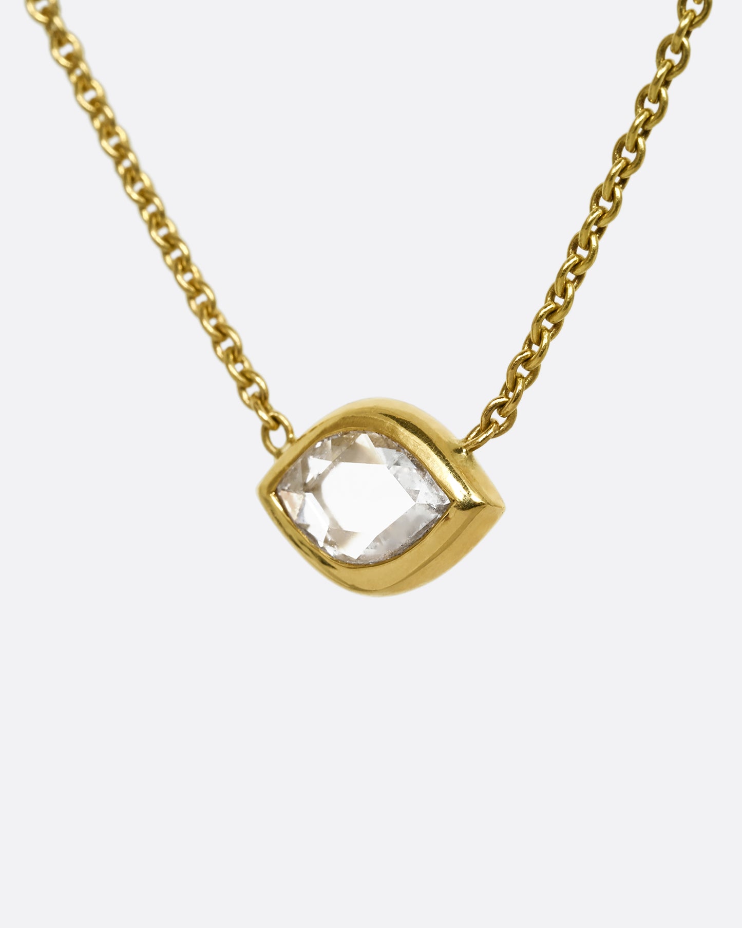 A yellow gold necklace with a  marquis shaped diamond. Shown from the side.