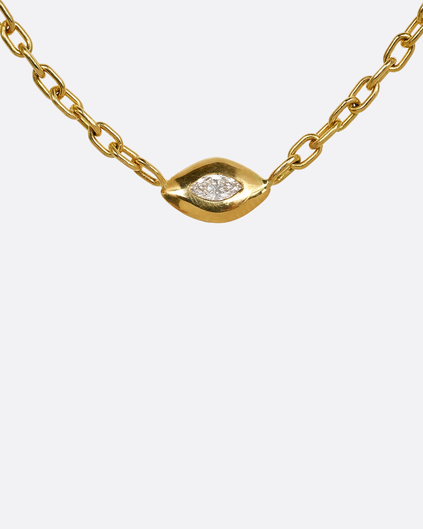 A yellow gold necklace with a marquis diamond pendant. Shown from the front.