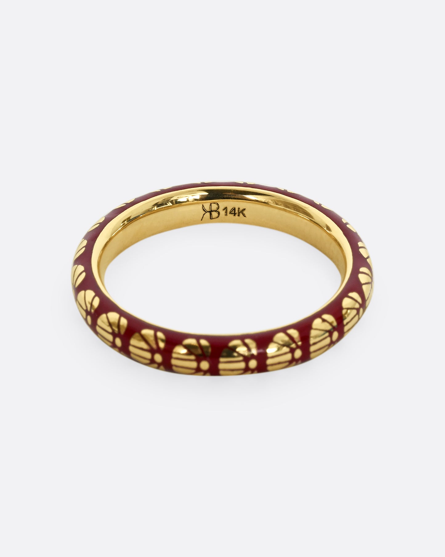 A yellow gold ring with burgundy enamel and a floral motif around the entire band.