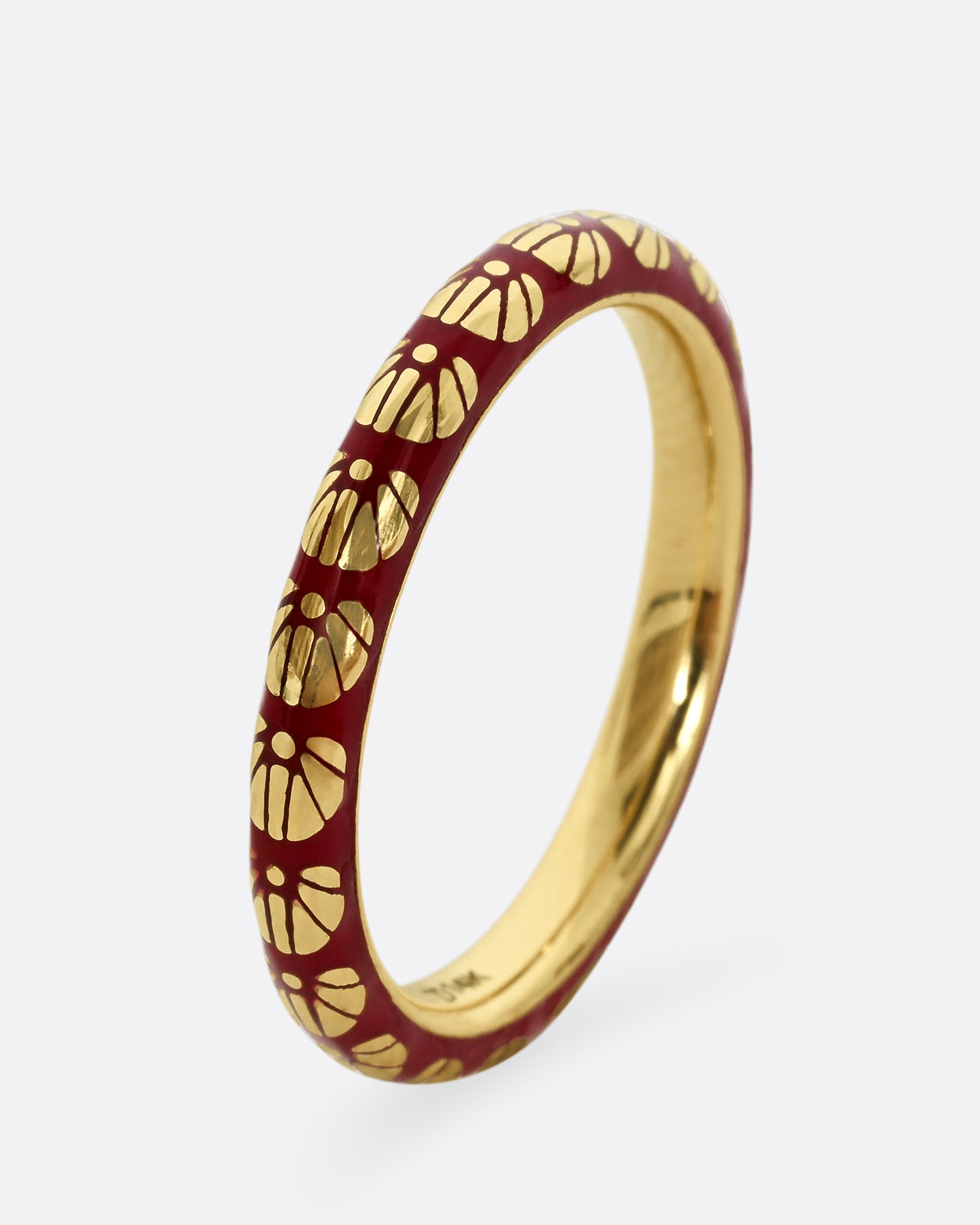 A yellow gold ring with burgundy enamel and a floral motif around the entire band.