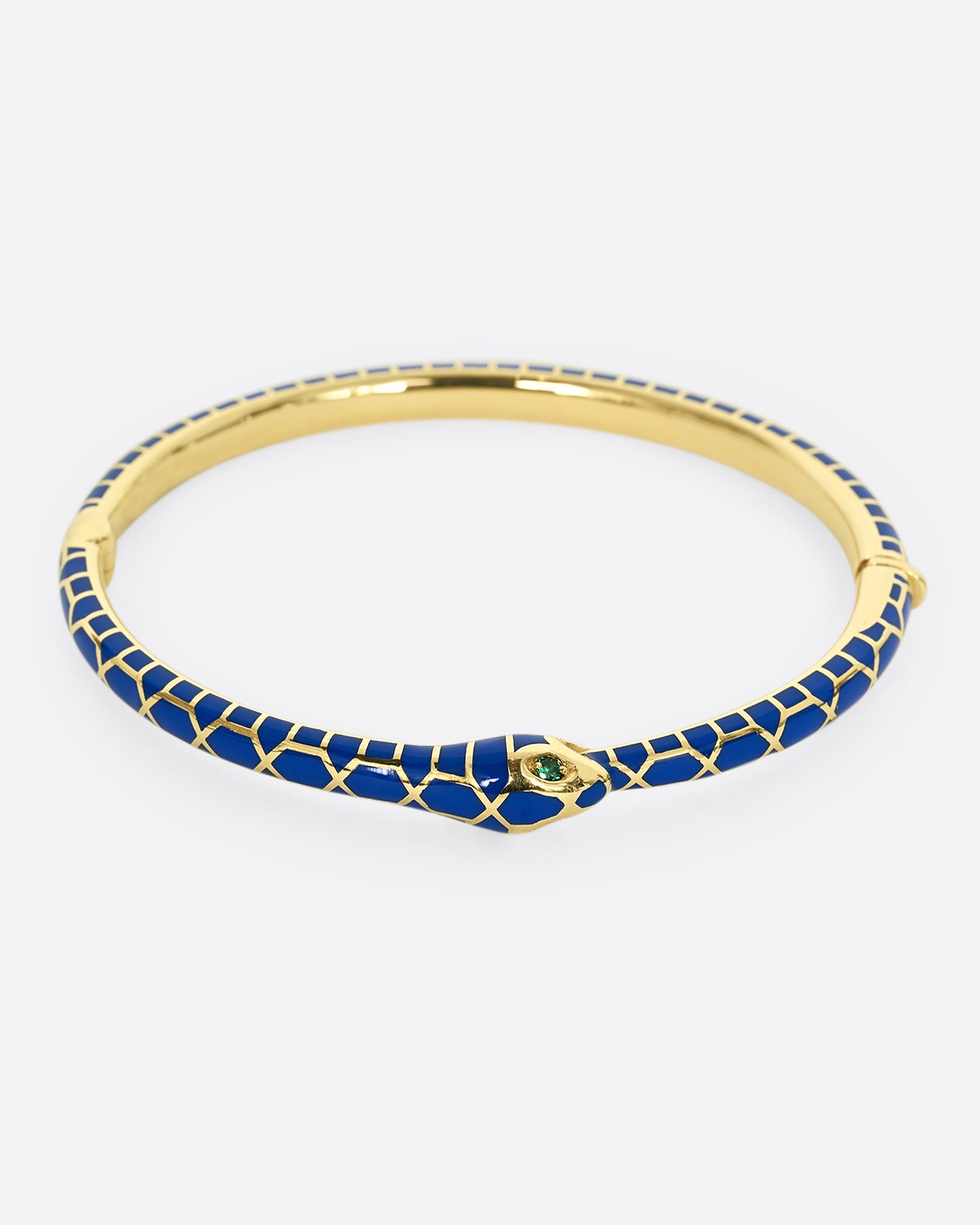 A yellow gold bracelet with blue enamel and emerald eyes. Shown from the front.