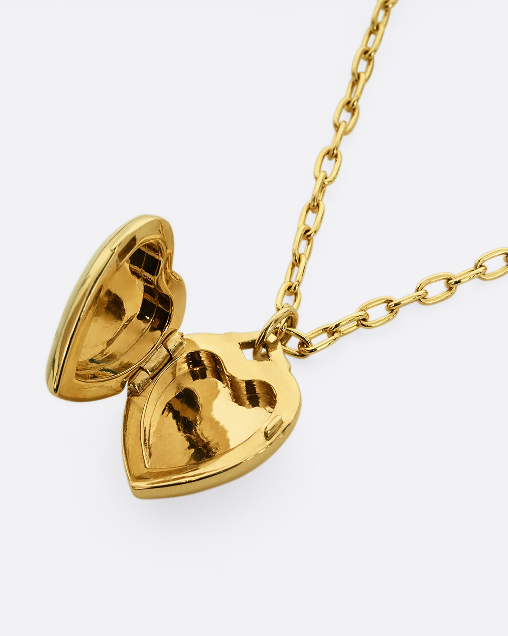 A yellow gold heart shaped locket with a multicolor floral motif on a heavy chain. Shown laying flat, open.