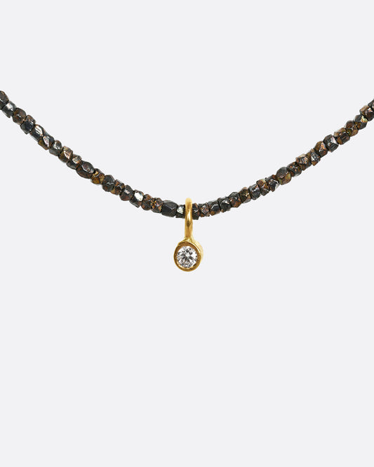 An oxidized silver necklace with a single diamond pendant. Shown from the front.