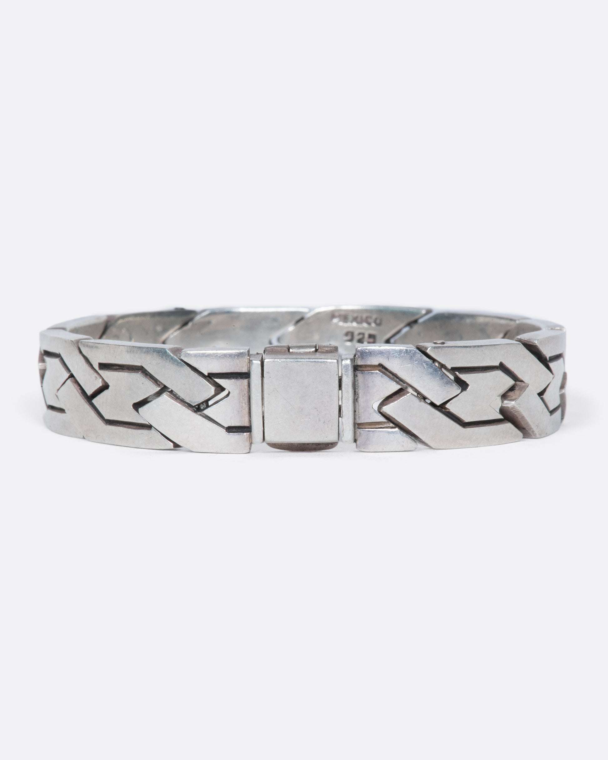 A vintage sterling silver flat chain bracelet with a woven-link design. The large, flat links reflect light making this piece especially eye-catching.