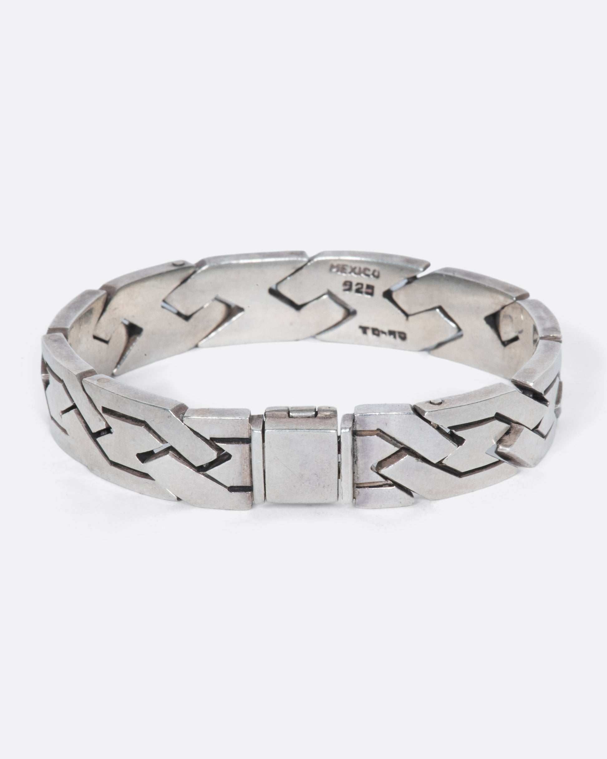 A vintage sterling silver flat chain bracelet with a woven-link design. The large, flat links reflect light making this piece especially eye-catching.