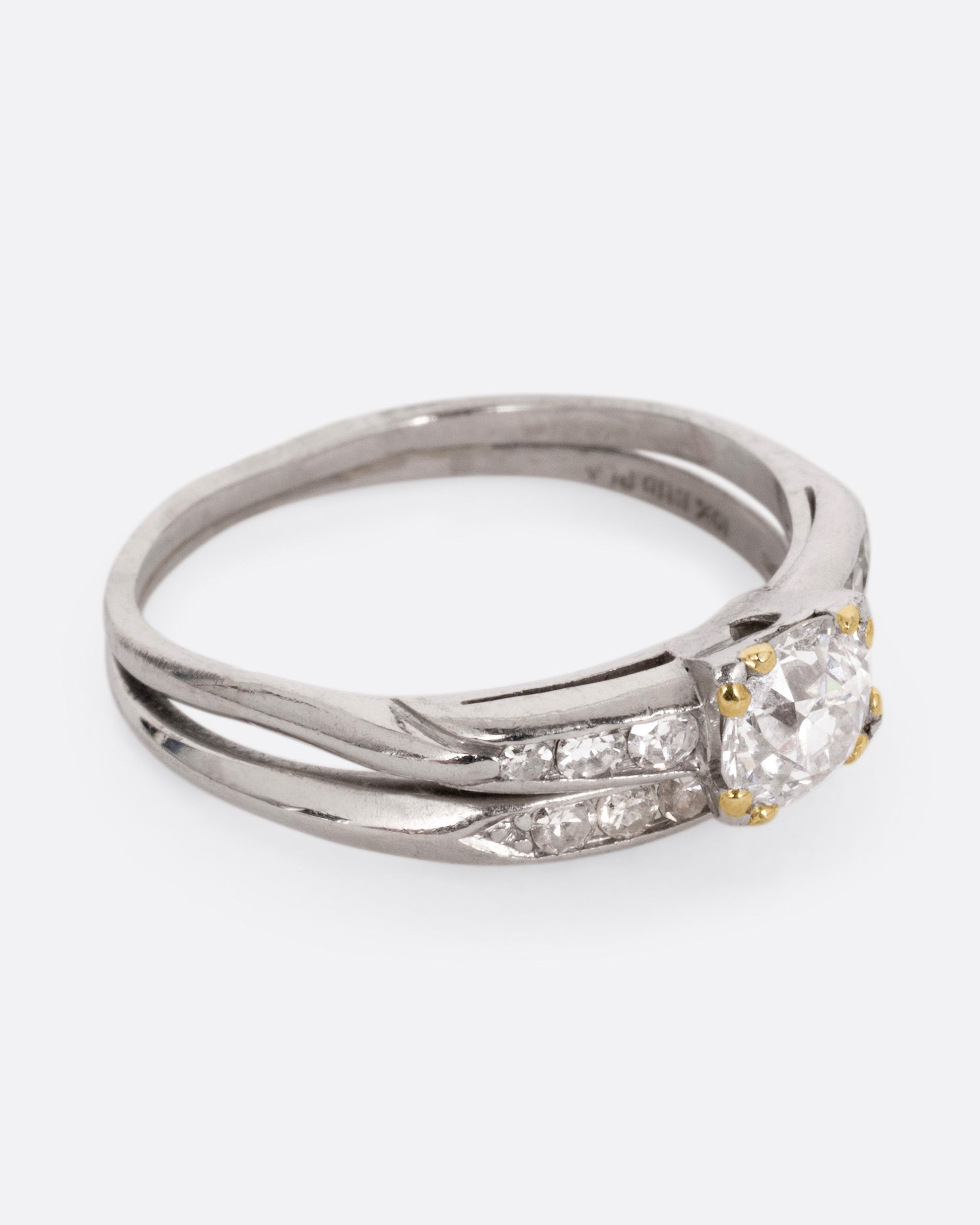 A platinum ring with an Old European cut diamond and a split shank, shown from the side.