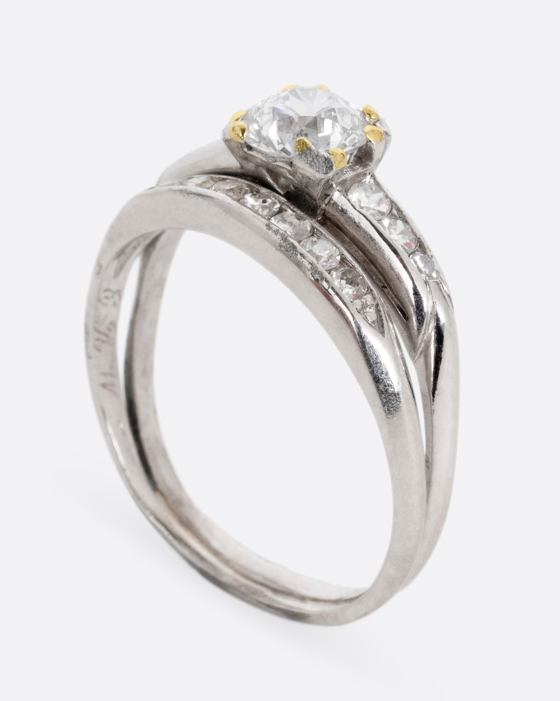 A platinum ring with an Old European cut diamond and a split shank, shown standing up from the side.
