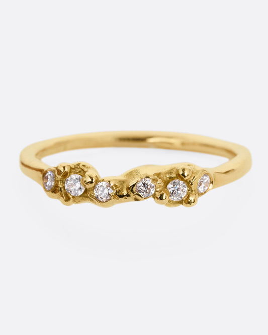 A yellow gold ring with a queue of diamonds set into a textural front. Shown from the front.