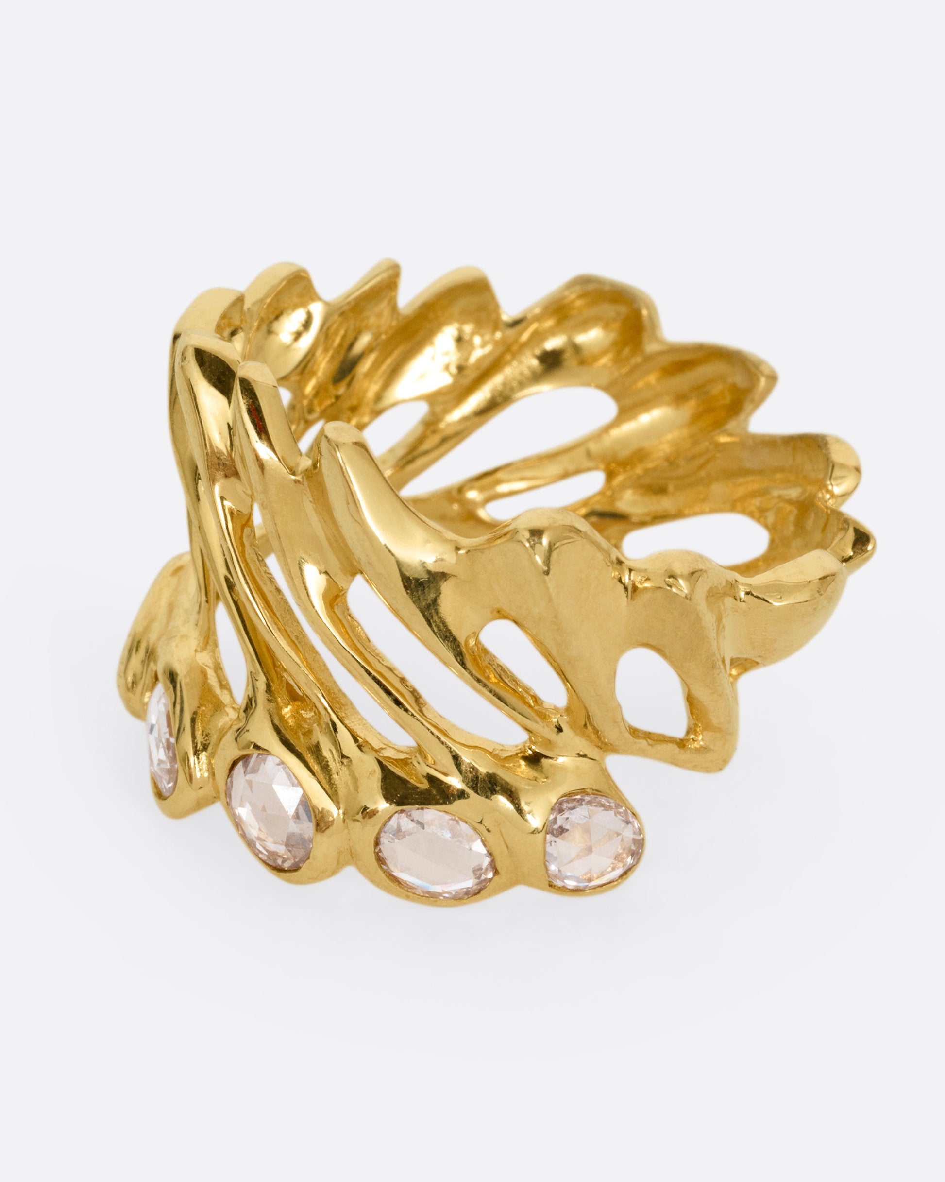 A yellow gold ring with intertwined strands and a queue of rose cut diamonds on its edge, shown from the side.