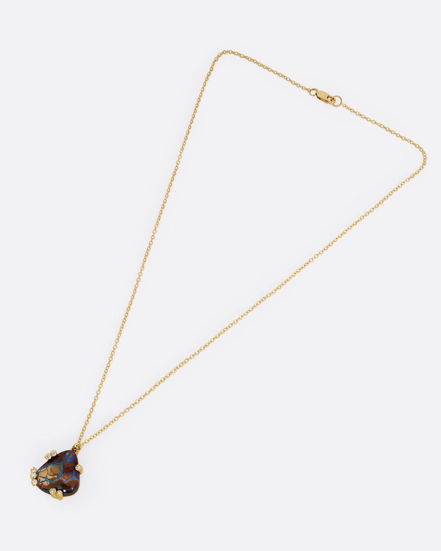 A yellow gold cable chain necklace with a free-form boulder opal and diamond anemones. Shown from the front.
